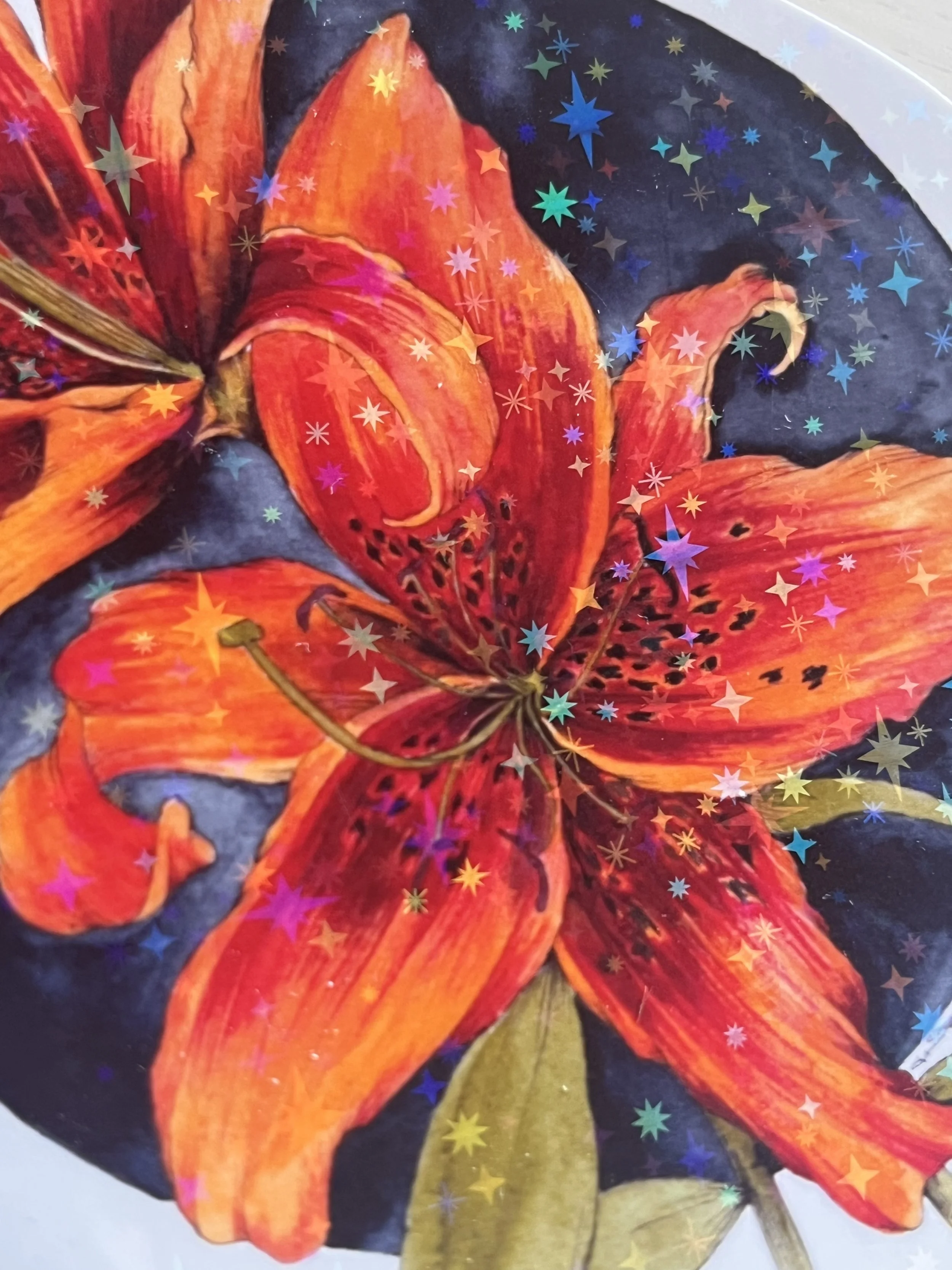 Close up of a lily sticker showing the orange colour and the star shaped sparkles in the holographic sticker.