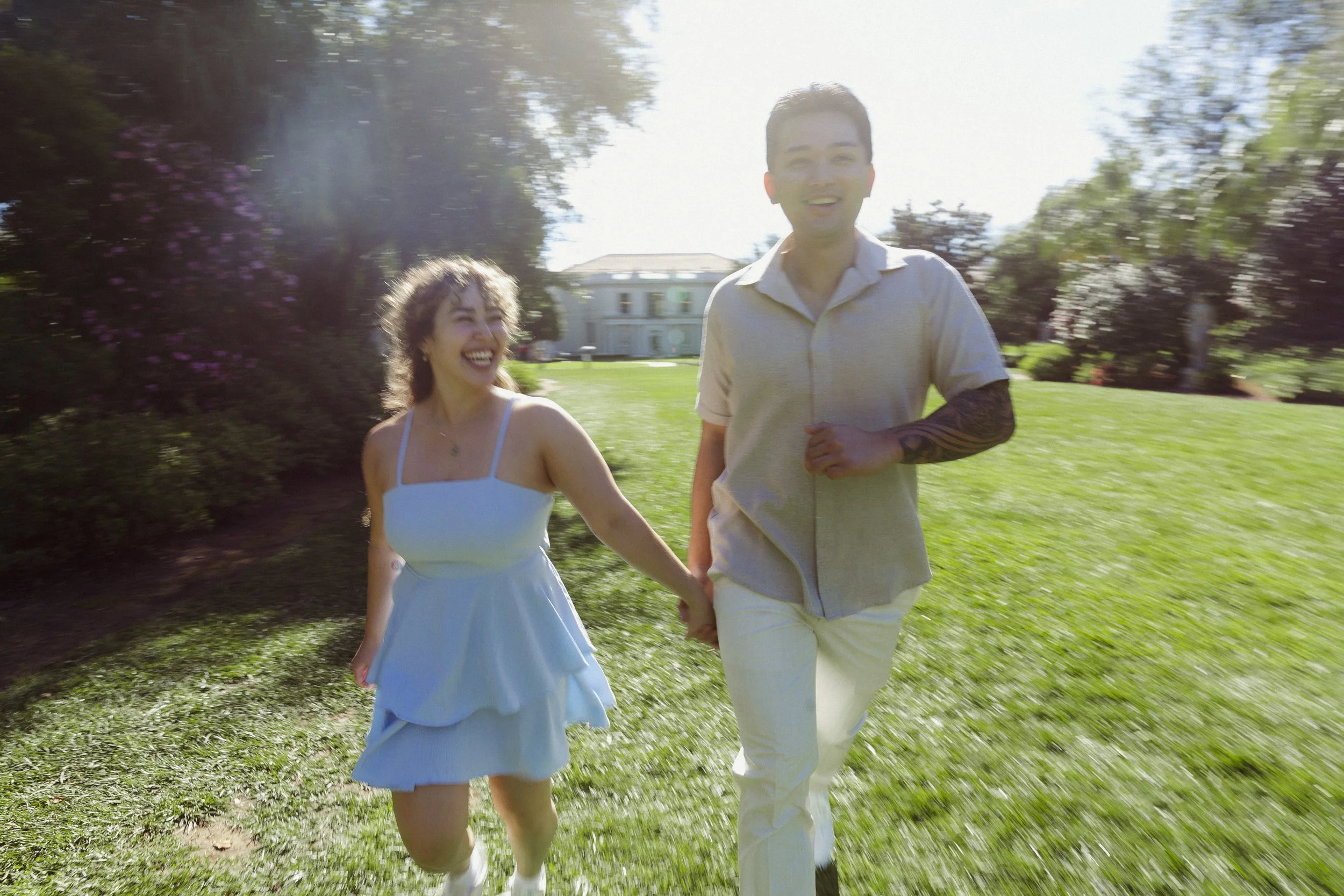 Couple running through a grassy courtyard at The Huntington Library.