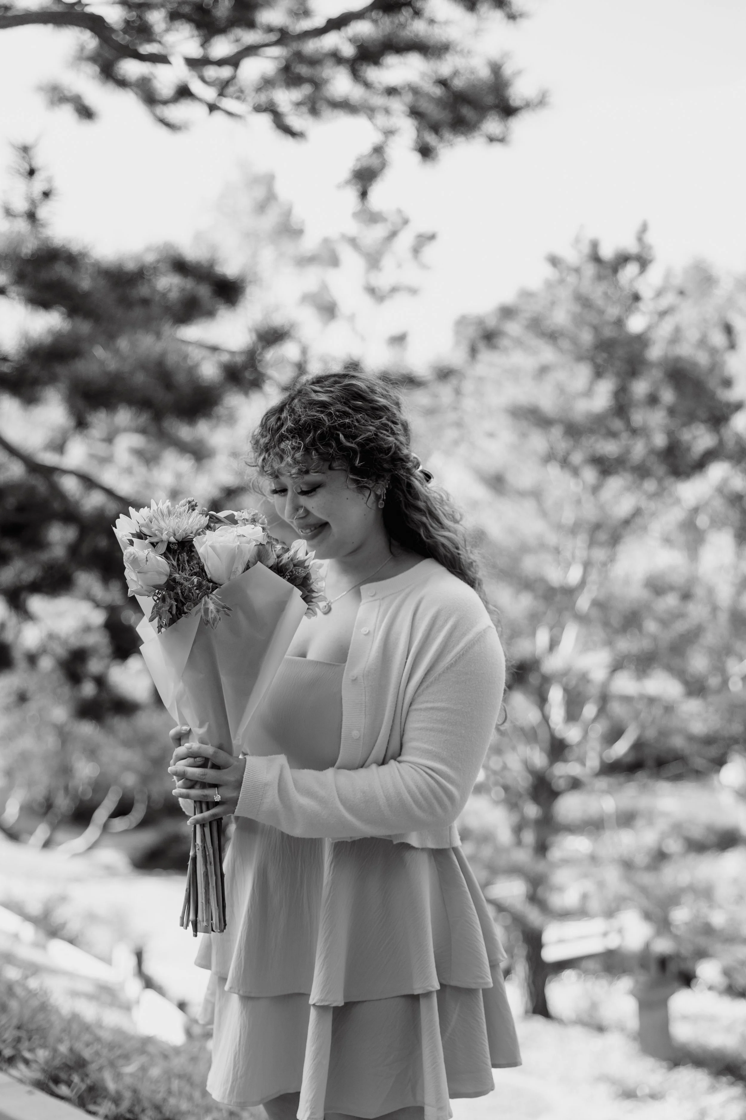 Bride to be smelling a bouquet of flowers during her engagement session at The Huntington Library.