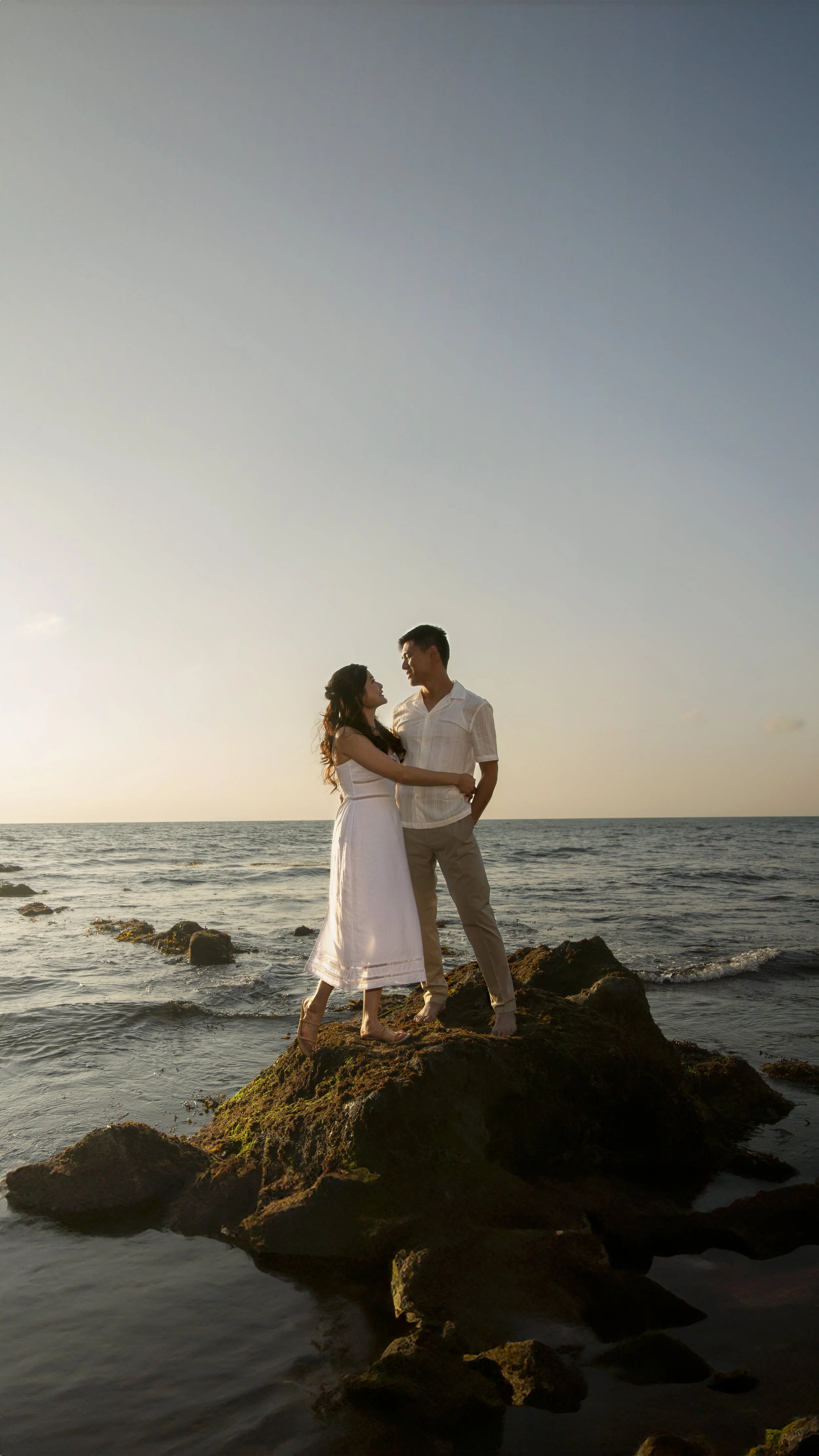 Vincent and Megan embracing during a sunset engagement session at Crystal Cove in Orange County