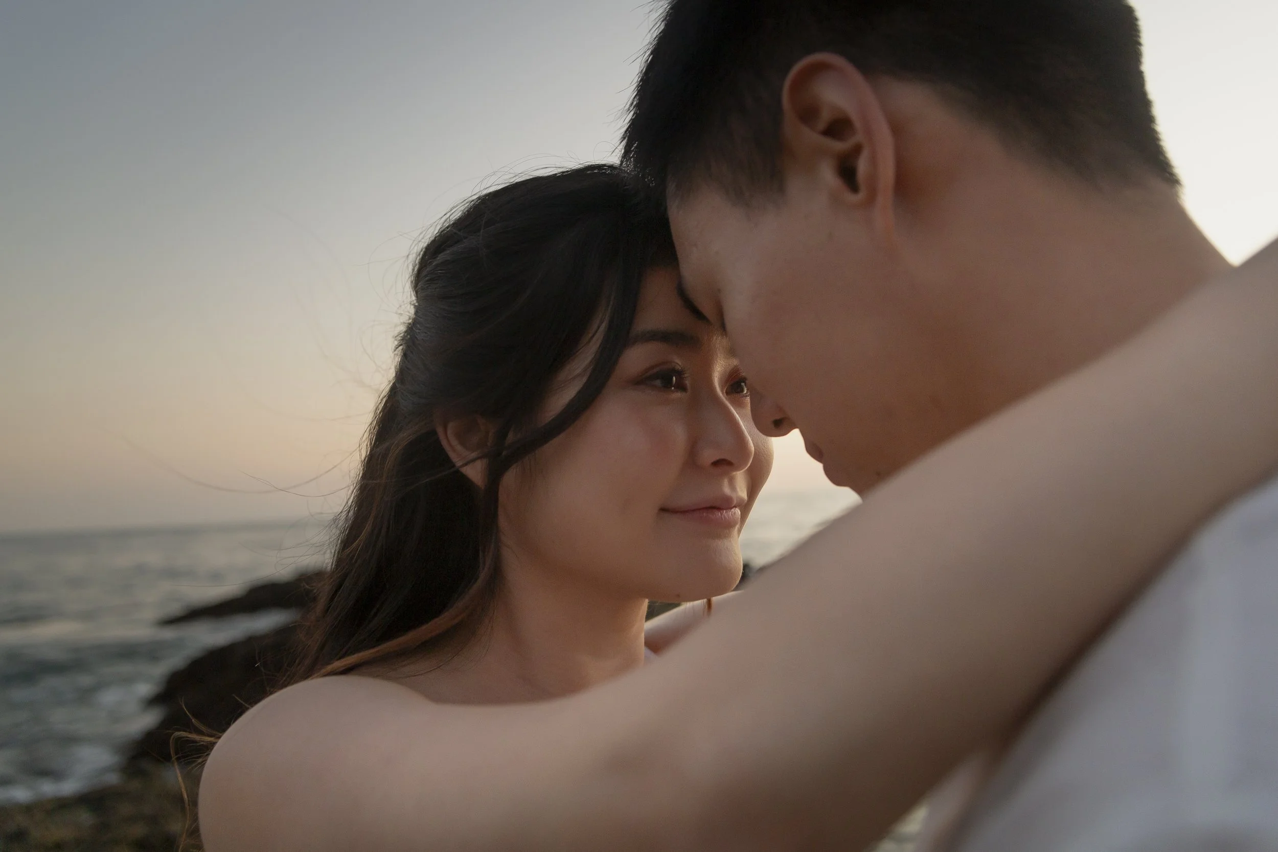 Close portrait of couple touching foreheads during a sunset engagement session at Crystal Cove.