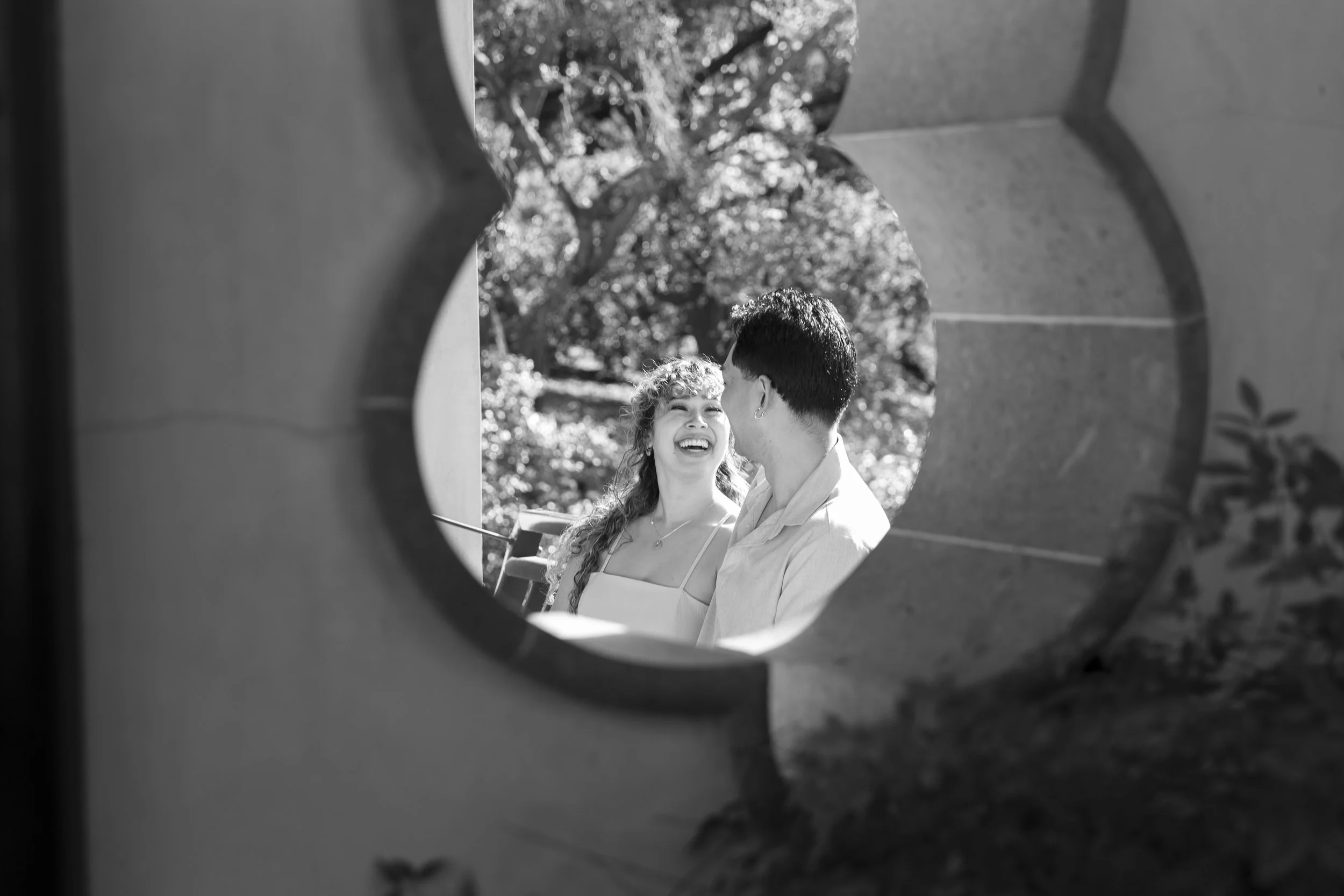 Couple framed through a window in the Chinese garden building at The Huntington Library.