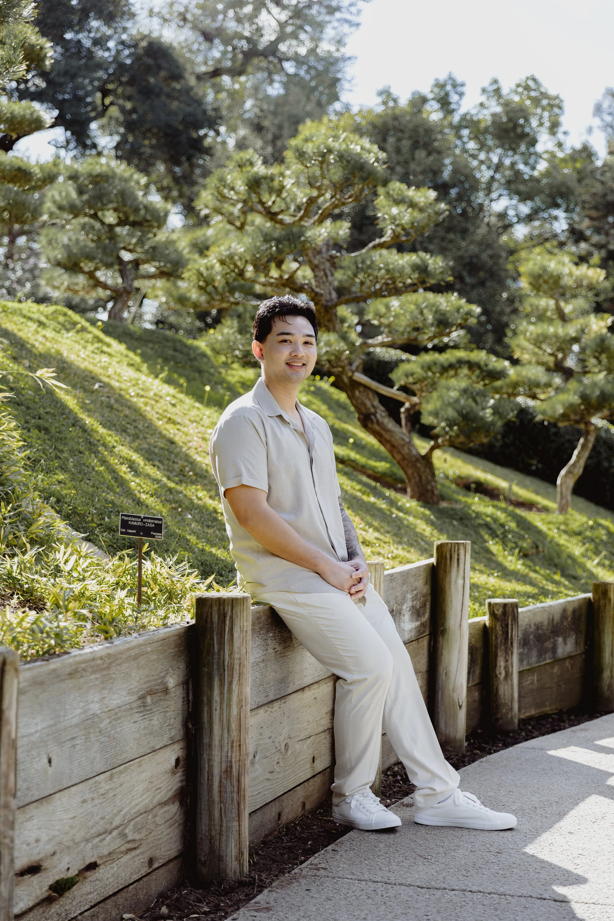 Portrait of groom to be seated in the gardens during an engagement session.
