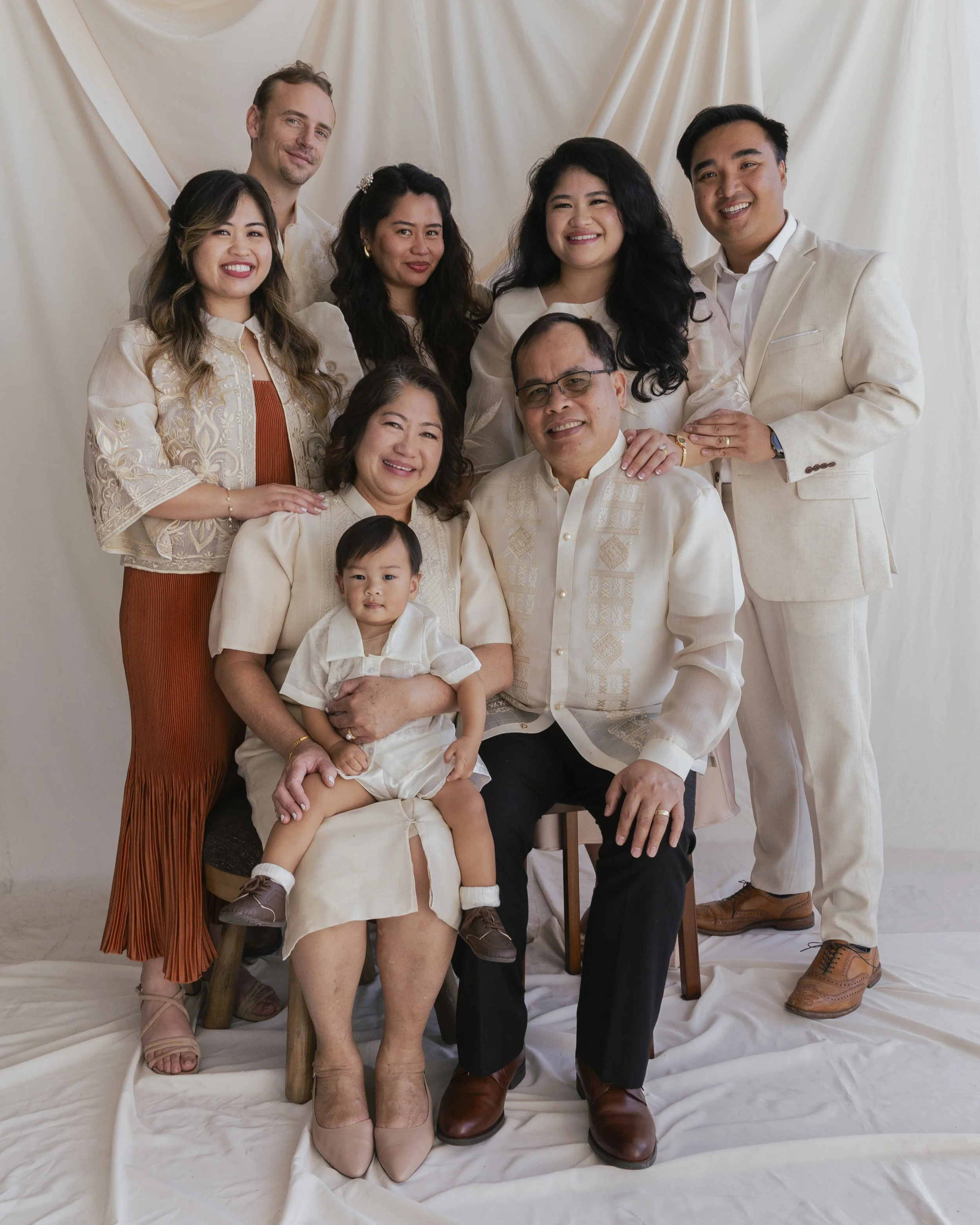 Family portrait in a softly lit studio with draped fabric background in Los Angeles.