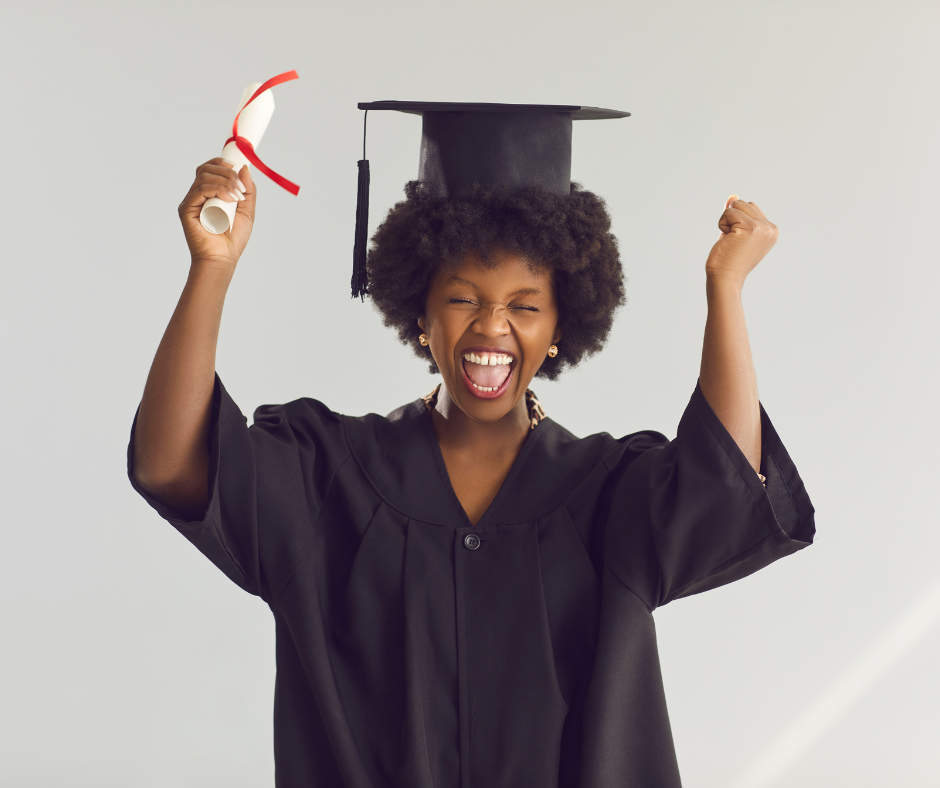 A young woman in a graduation cap and gown celebrating with a joyful expression, holding her diploma in one hand and raising her other fist in triumph.