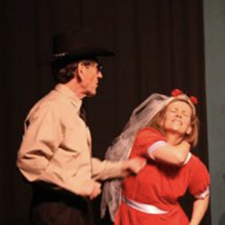 A man and a woman dressed in costumes performing on stage