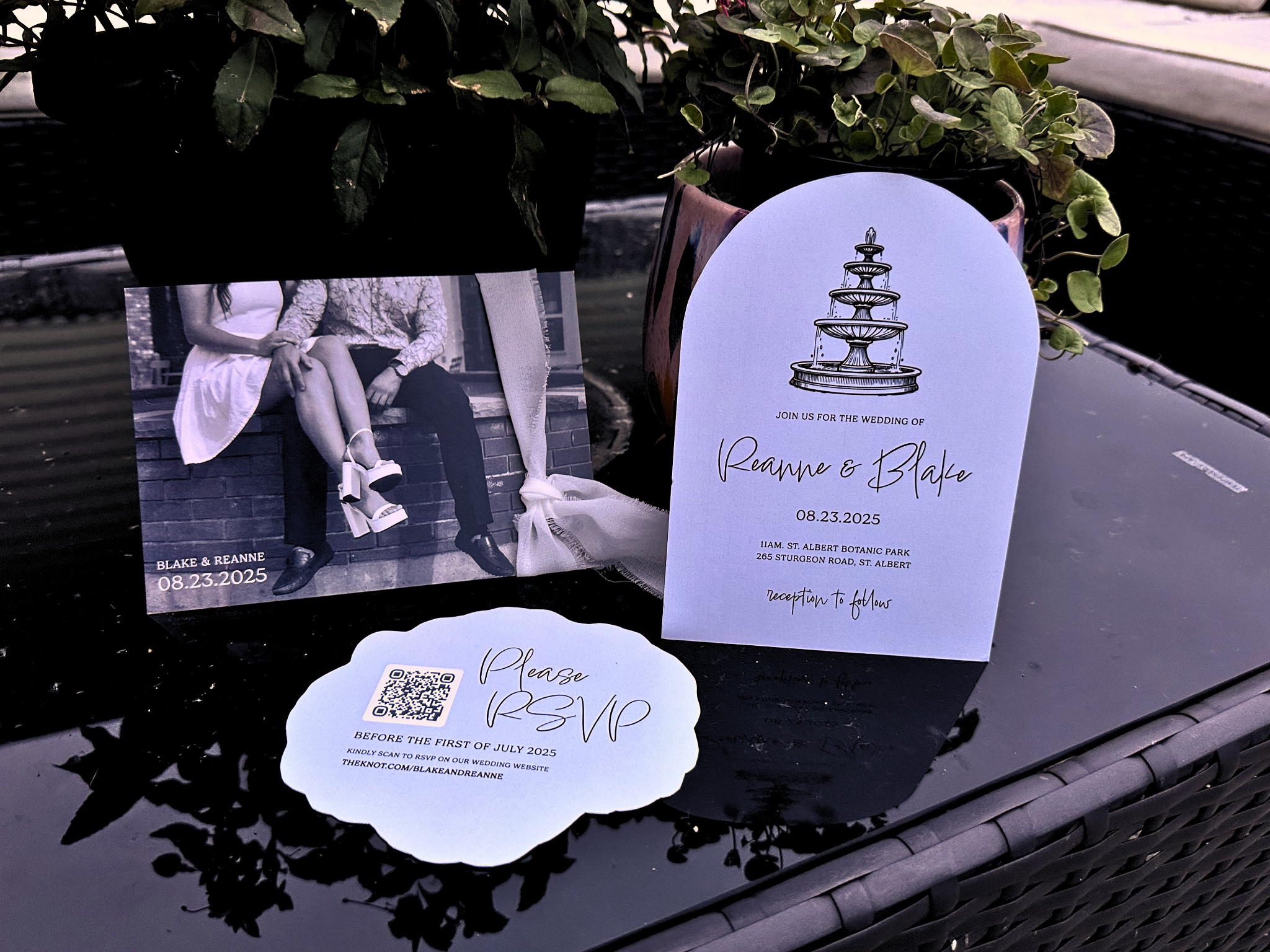 Wedding invitation cards and an anniversary photo of a couple. The invitation mentions the wedding of Reanne and Blake on August 23, 2025, at 11 AM at St. Albert Botanic Park, with a QR code for RSVP. The photo features a couple sitting together, the woman in a white dress and the man in darker clothing, against a brick background.