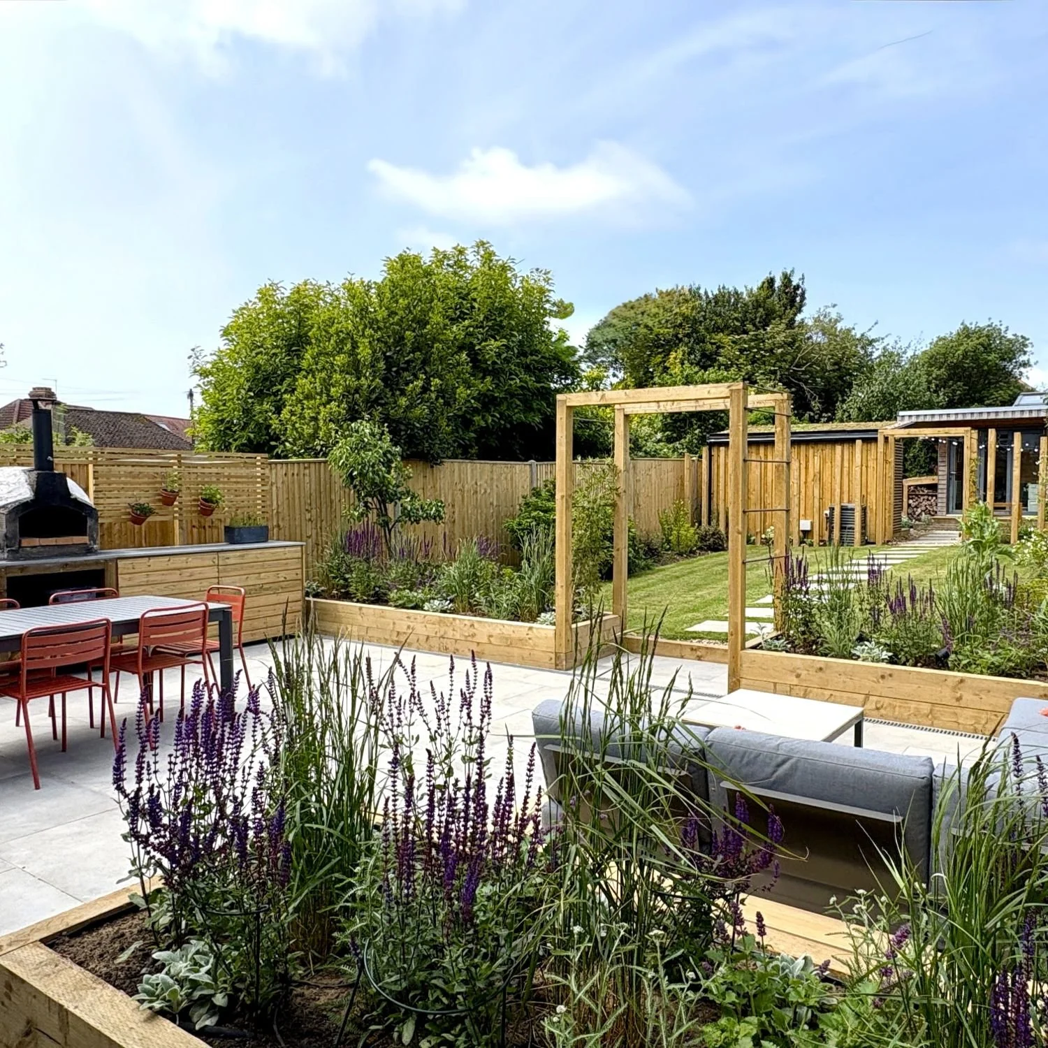 Generous outdoor kitchen, dining and seating close to the house, surrounded by planting