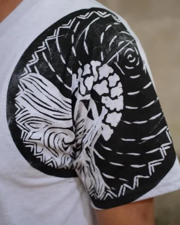 Manga de camiseta con diseño de una luna y un árbol en blanco y negro.