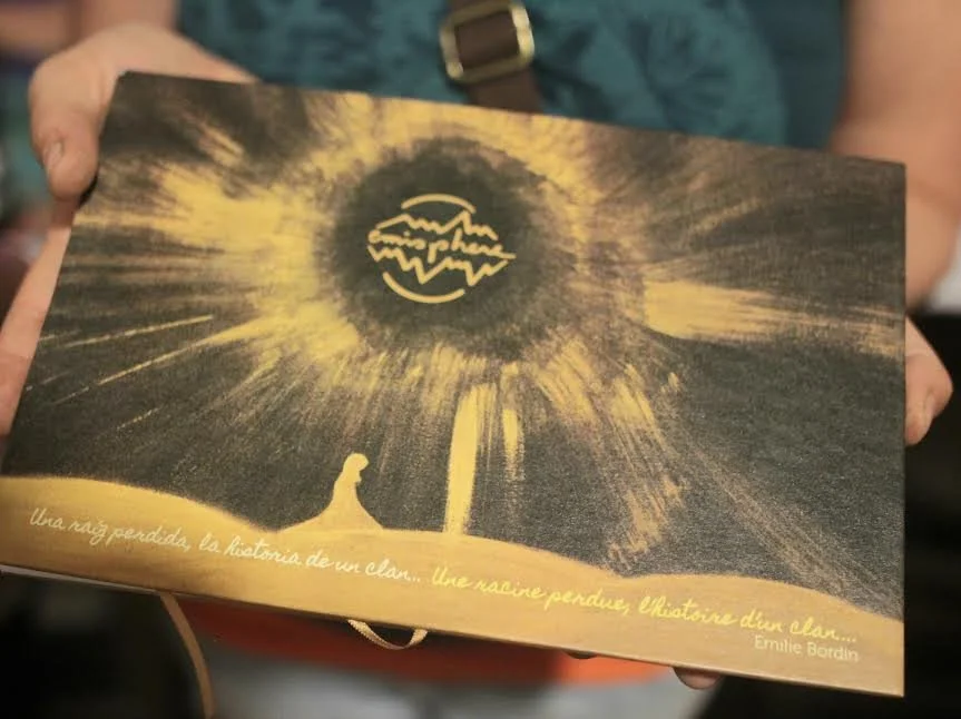 Ilustración en tonos oscuros, con un personaje sentado mirando hacia una explosión de luz en el cielo y una luna con un dibujo de caracol luminoso, con texto en español en la parte inferior.