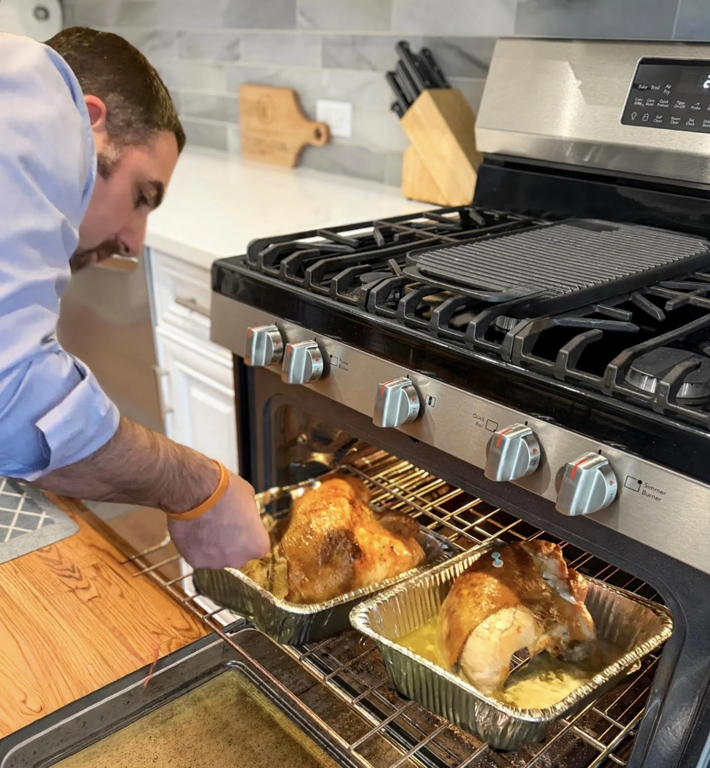 Husband cooking two turkeys for Thanksgiving dinner.