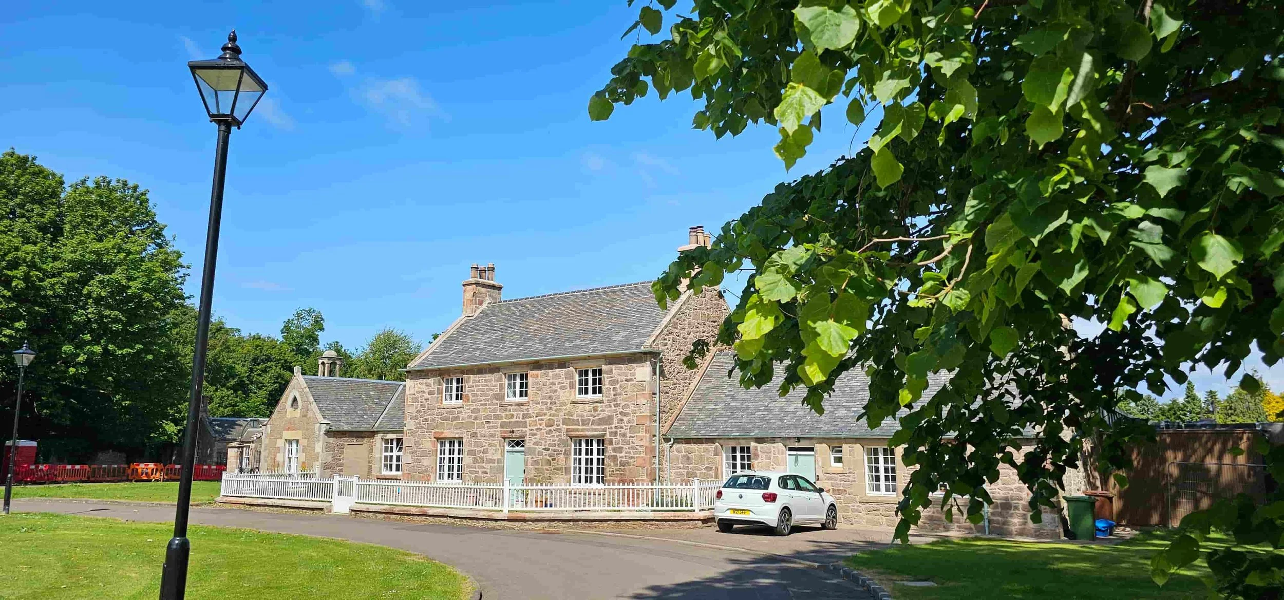 Restored stone building set within landscaped grounds in Scotland.