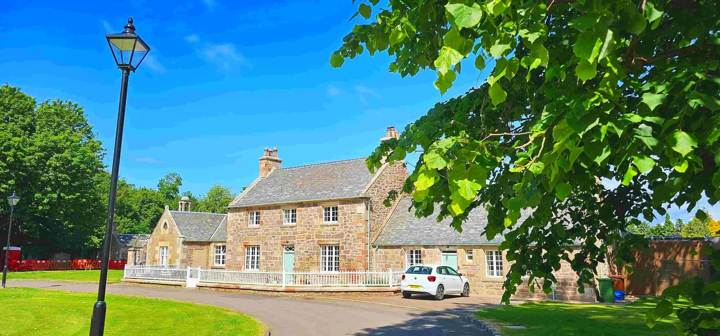 Restored stone building set within landscaped grounds in Scotland.