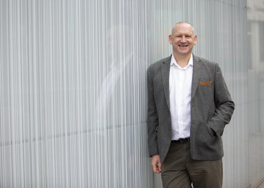 Image showing Kenny Telfer standing next to a wall in a professional photo
