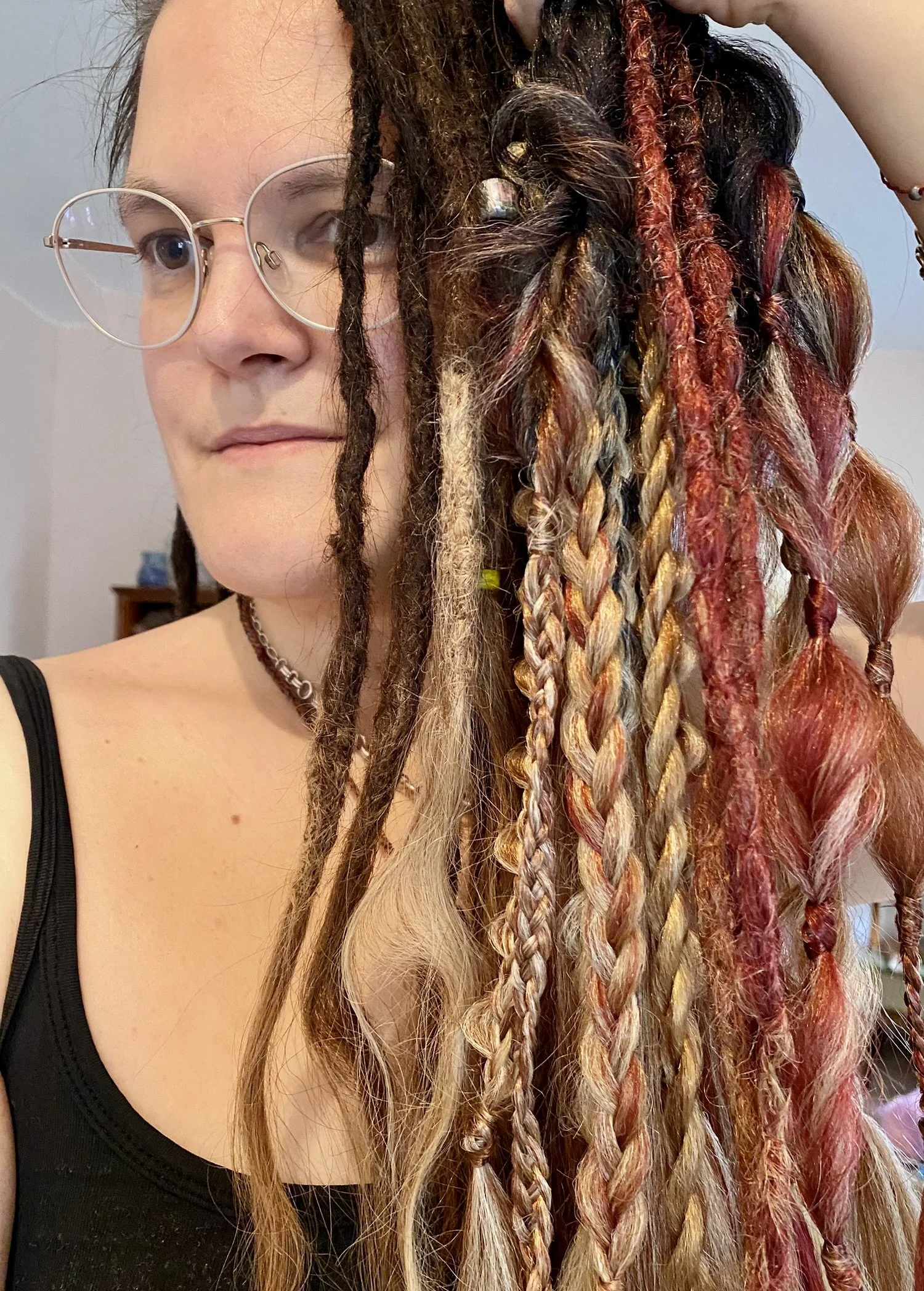 Frau mit rasta-ähnlichen, gefärbten Haaren und Brille.
