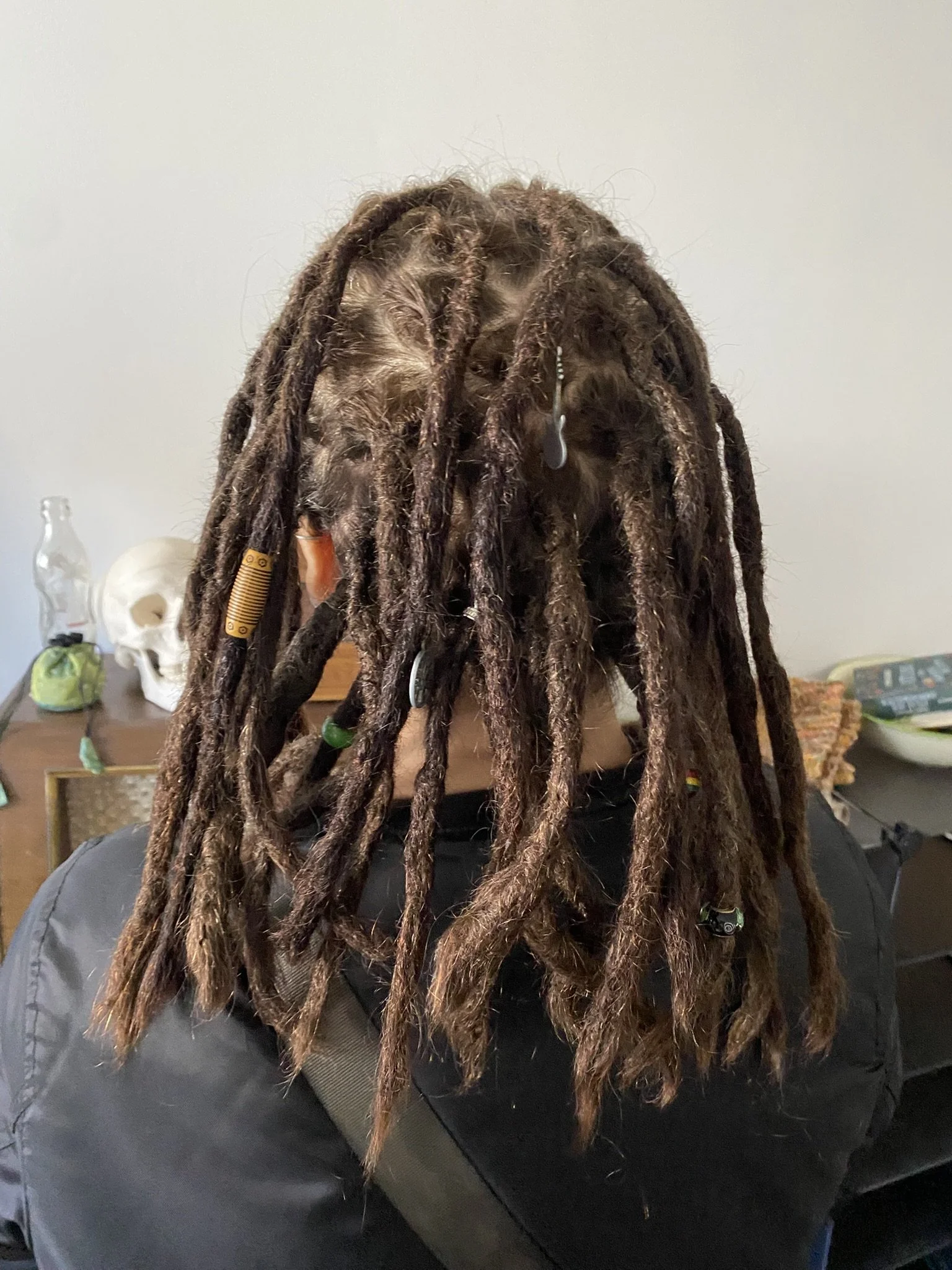 Frisbee mit Haaren, chaos, unordentliche Dreadlocks, dunkle Haare, Hintergrund mit Knochen, Flasche und anderen Gegenständen