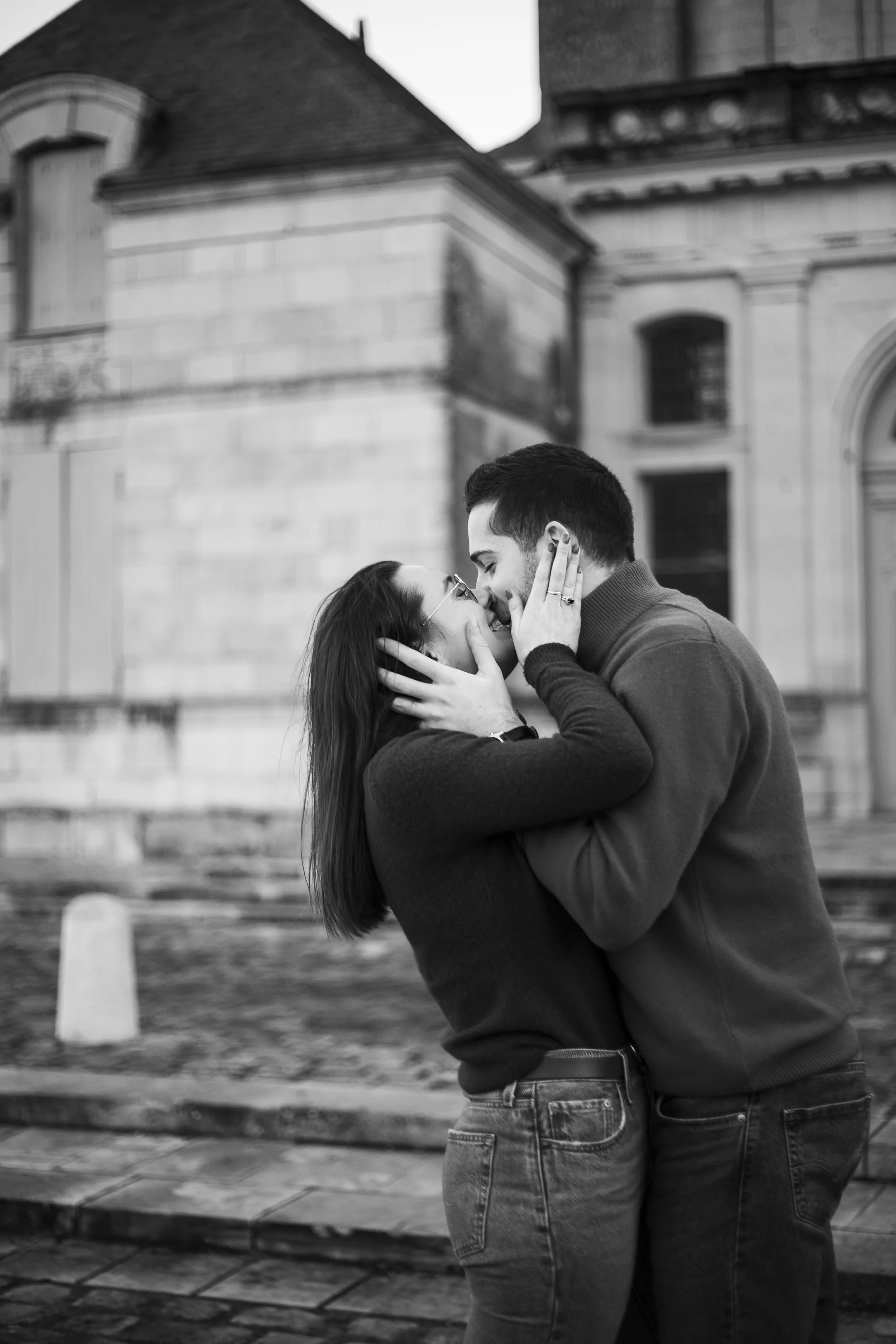 Un couple qui s'embrasse tendrement devant l'Abbaye de St Florent le Vieil, en noir et blanc.