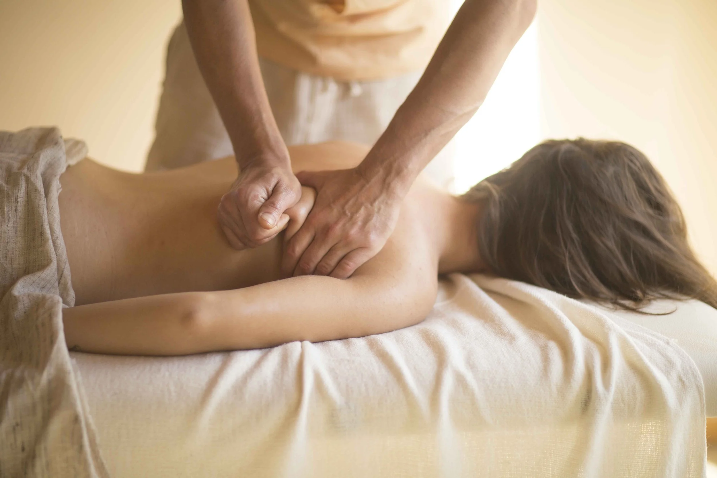 A person receiving a massage from a therapist in a peaceful setting.