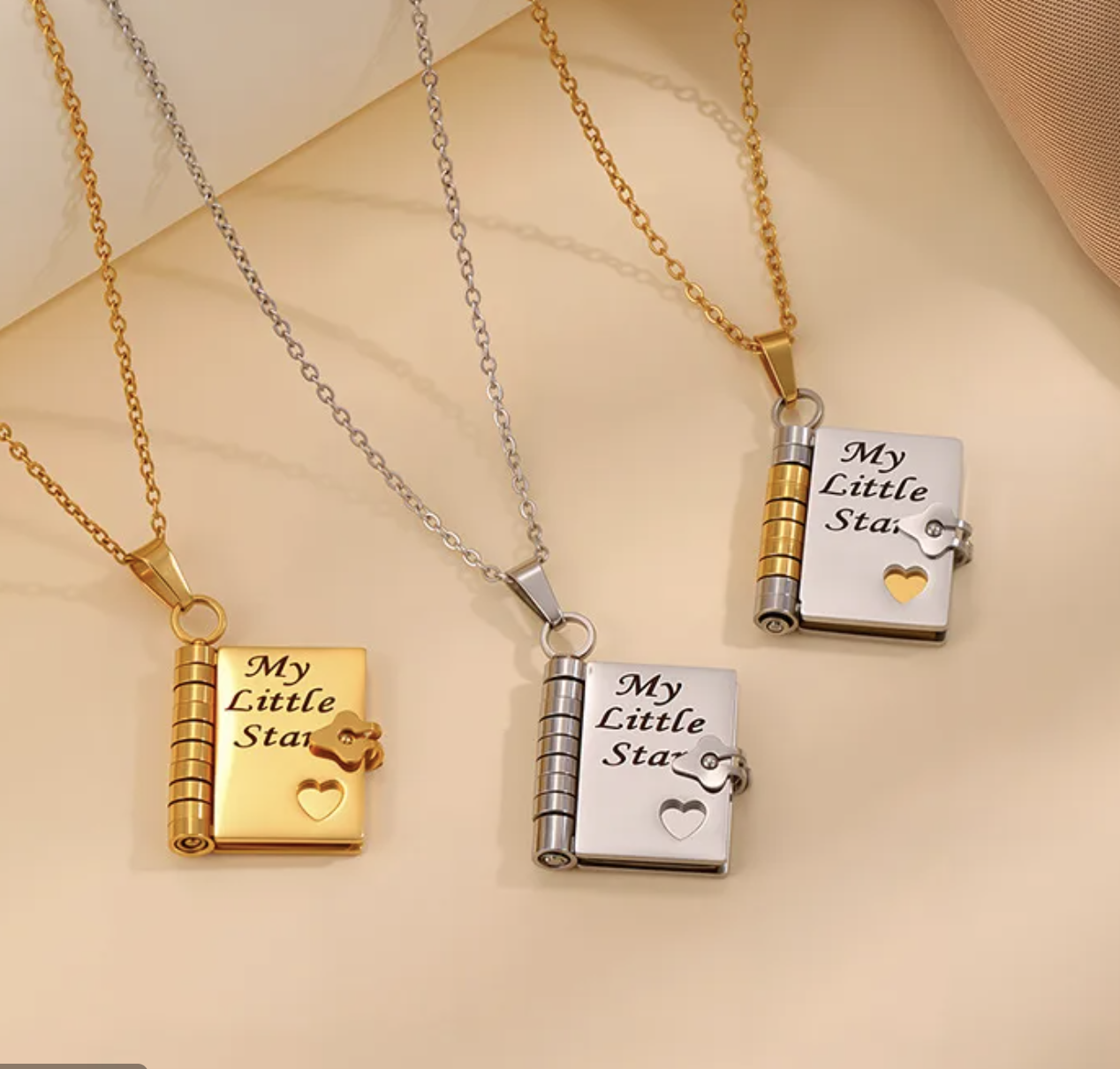 3 engraved necklaces shaped like a notebook.