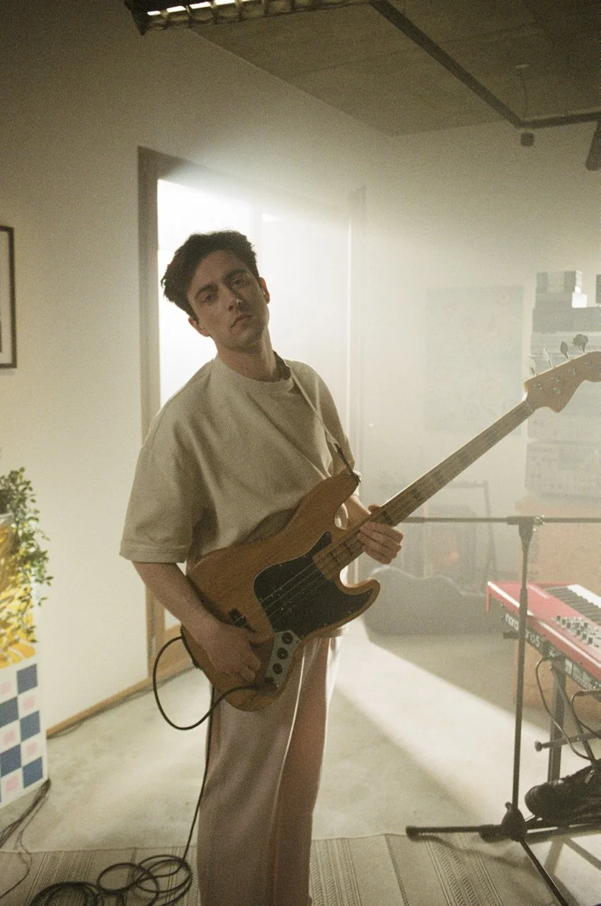 Junge mit E-Gitarre in einem Probenraum
