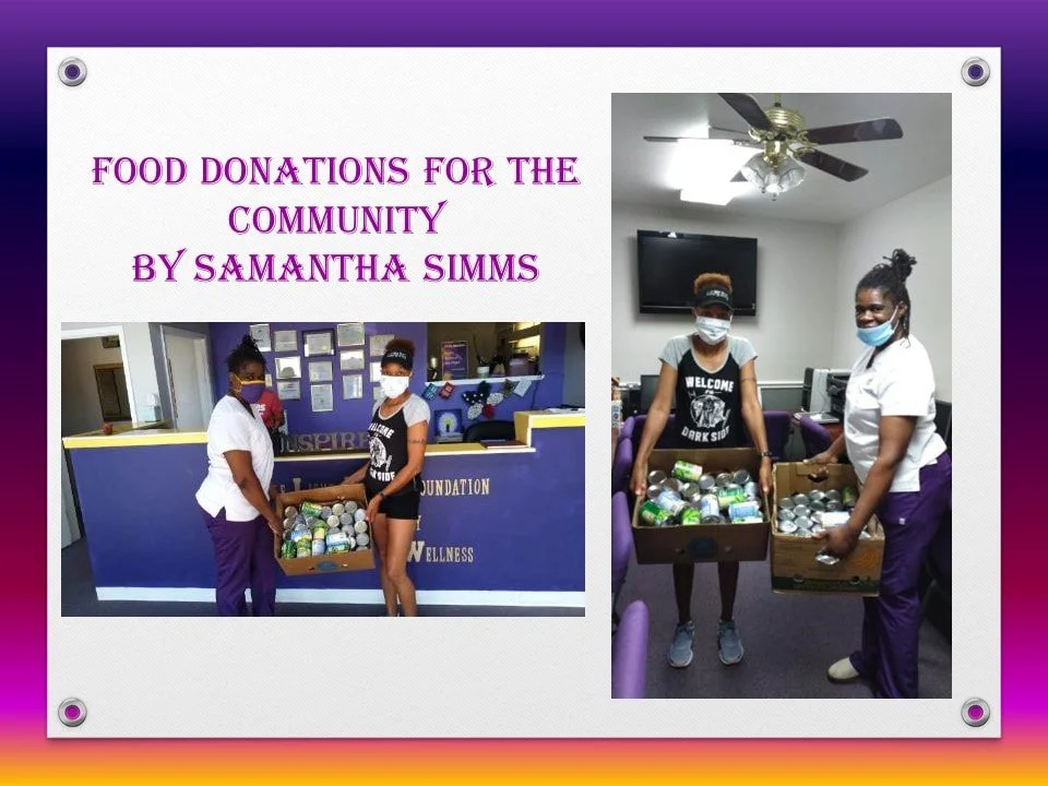 Three women wearing masks holding boxes filled with canned goods inside a community center.
