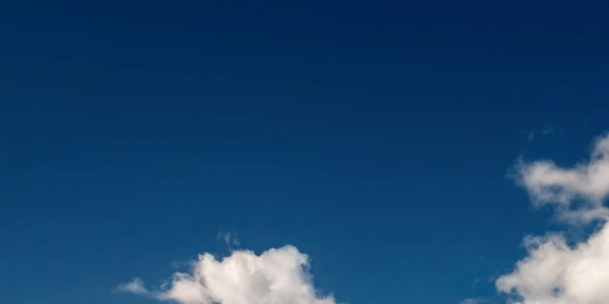 Clear blue sky with a few white clouds.