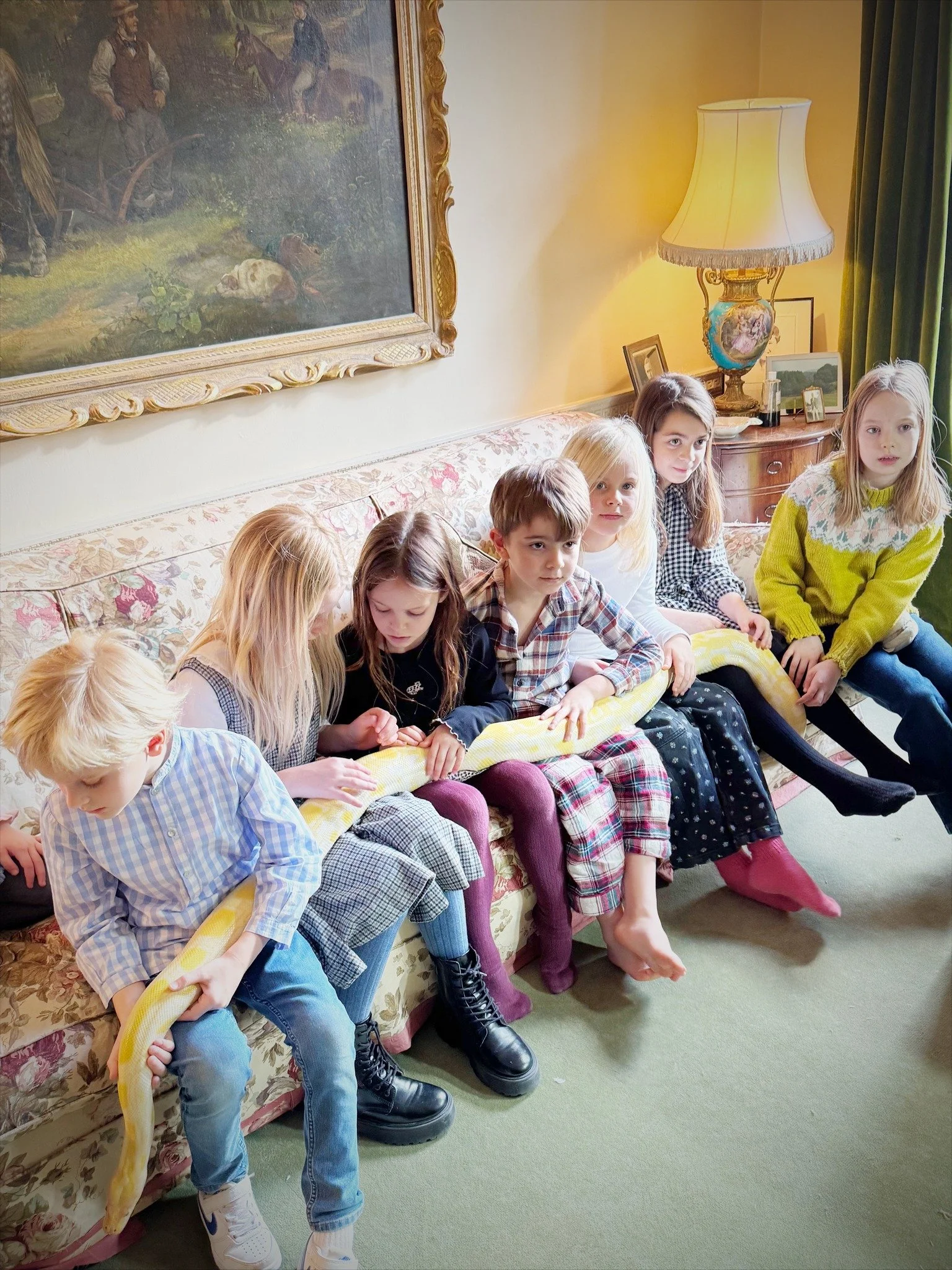 Small group of children sitting quietly on sofas during a guided reptile party experience