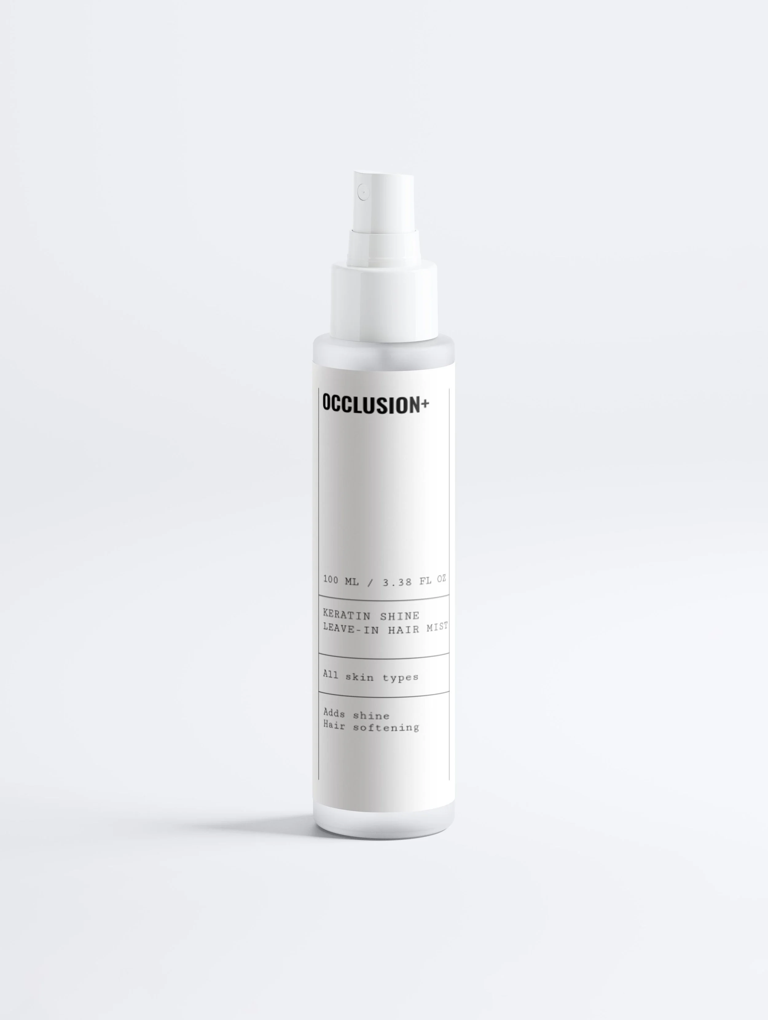 A white spray bottle labeled 'OCCLUSION+' with details about keratin shine leave-in hair mist, suitable for all skin types, designed to add shine and soften hair.