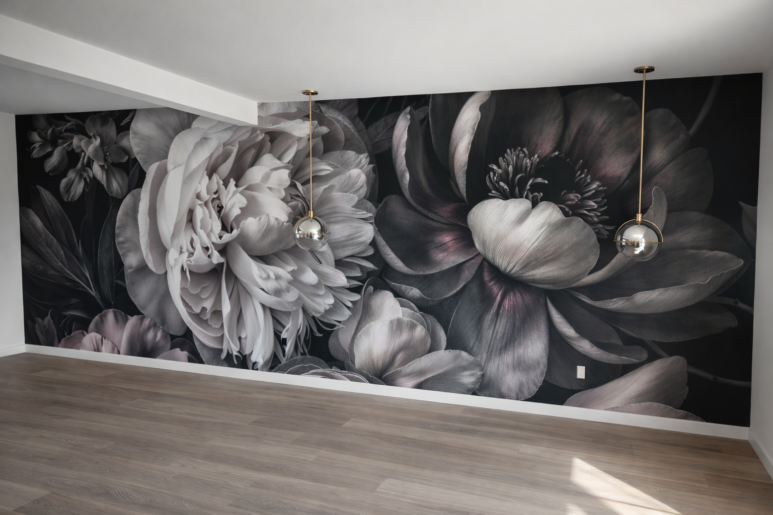 Black and white floral mural wall in a modern room with hardwood flooring and two hanging metallic pendant lights.