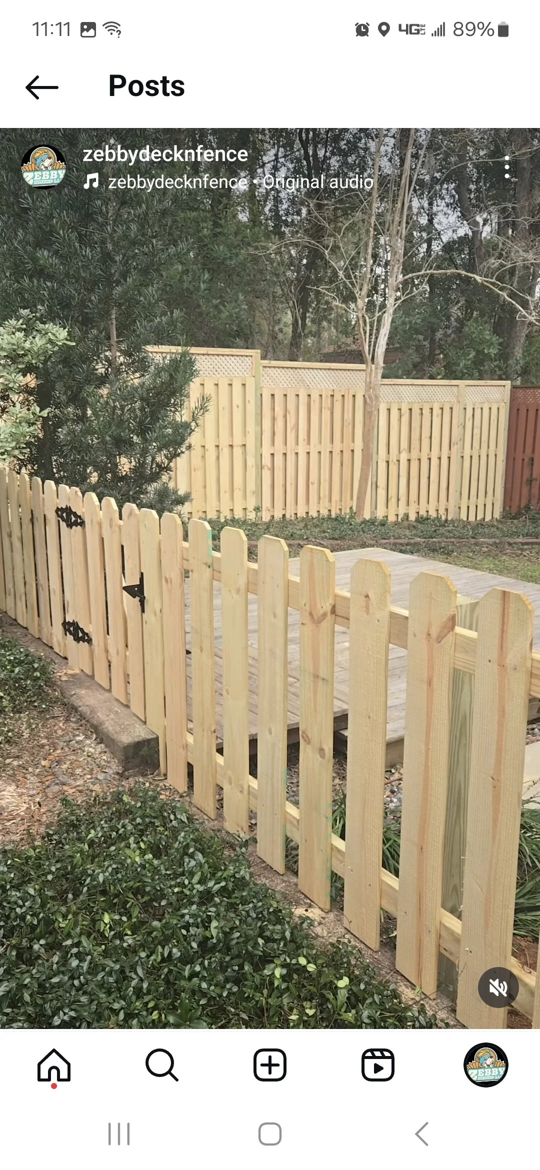 New wooden picket fence in a backyard, with a small wooden deck installed inside.
