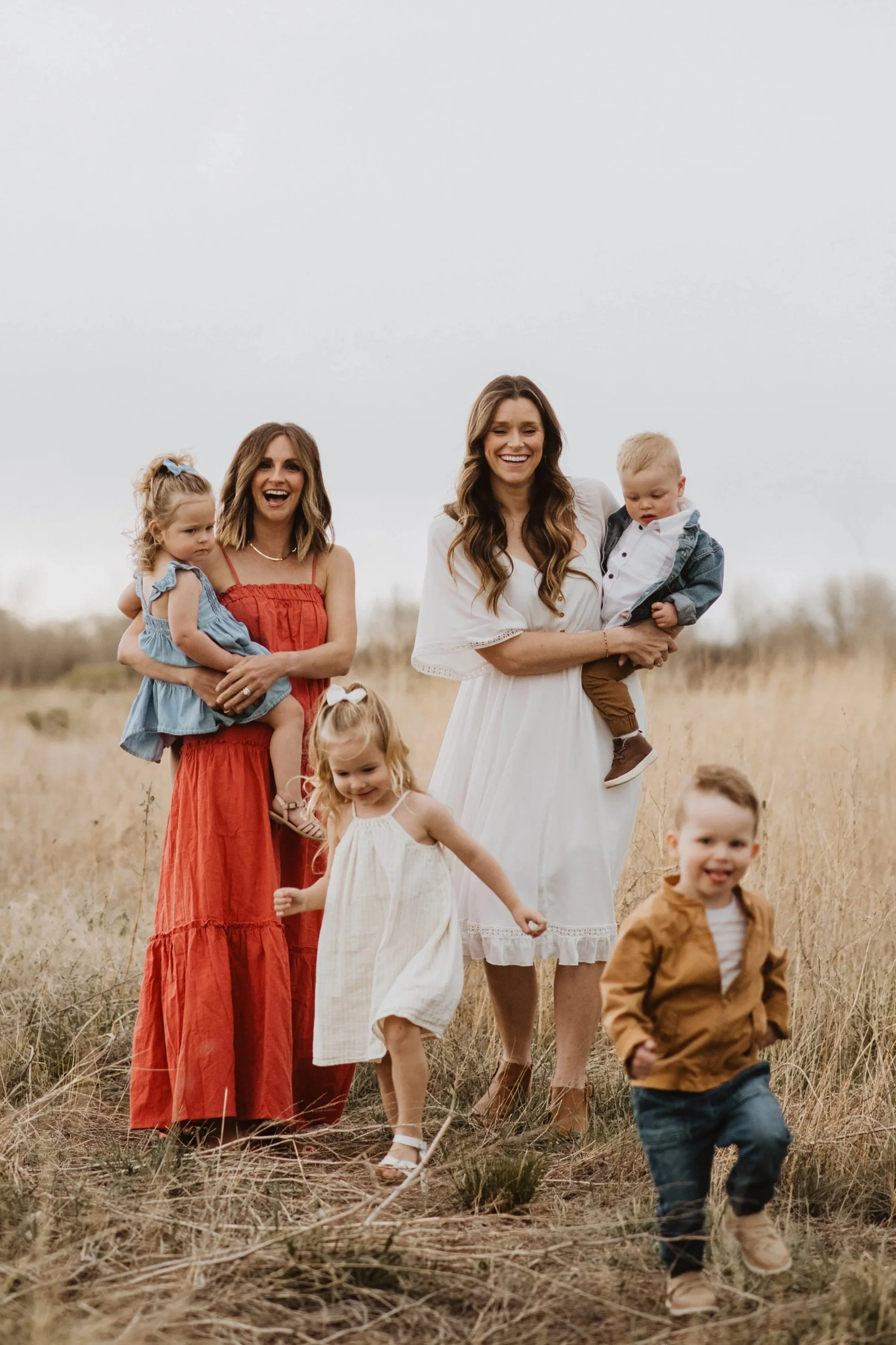 Kelly Sinning and Hannah Dorsher with their children, laughing while watching them play, therapy for moms in fort collins colorado
