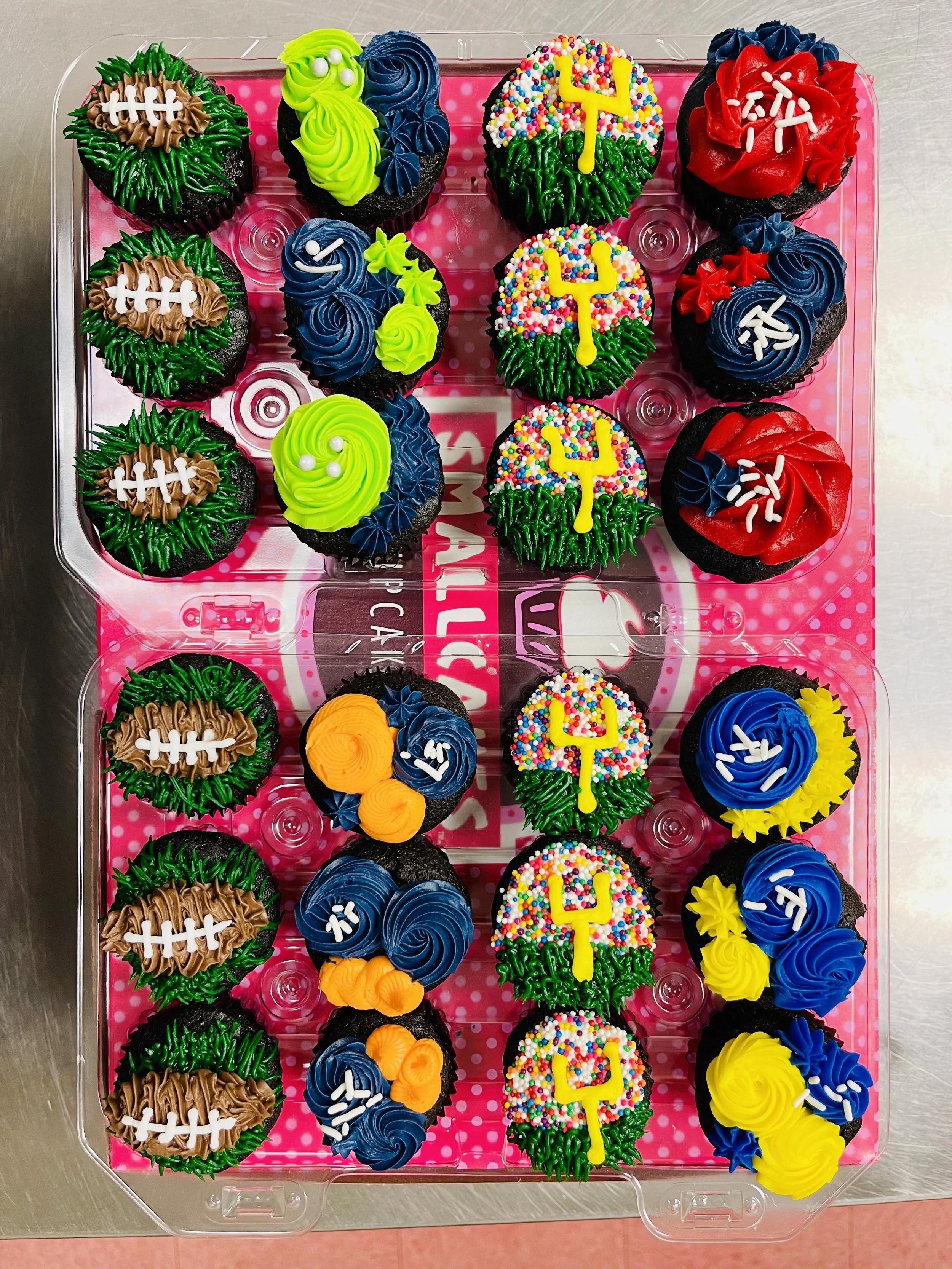 Cupcakes decorated with football, sports equipment, and colorful sprinkles for a sports-themed celebration.