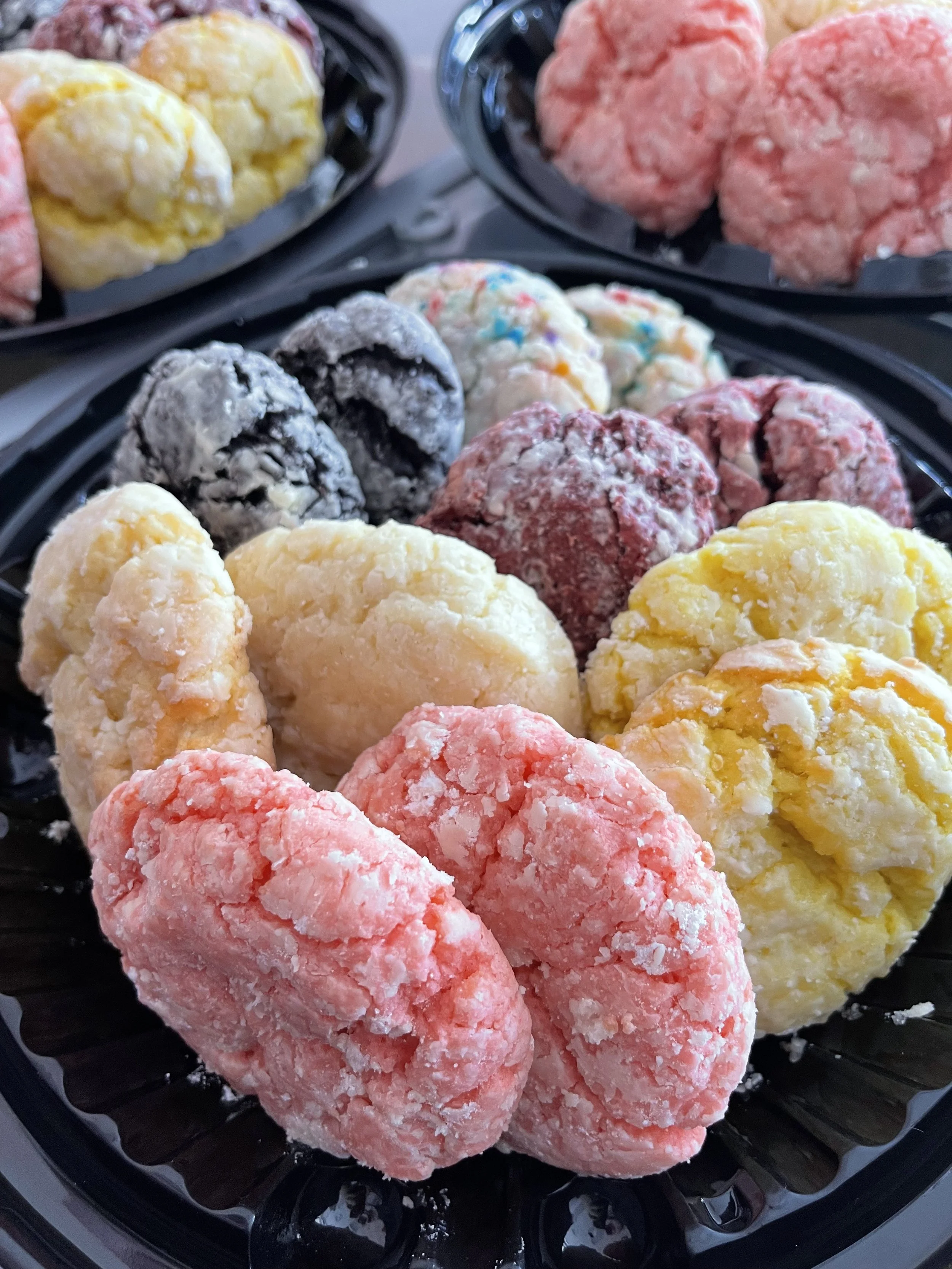Assorted colorful ice cream balls in a black tray.
