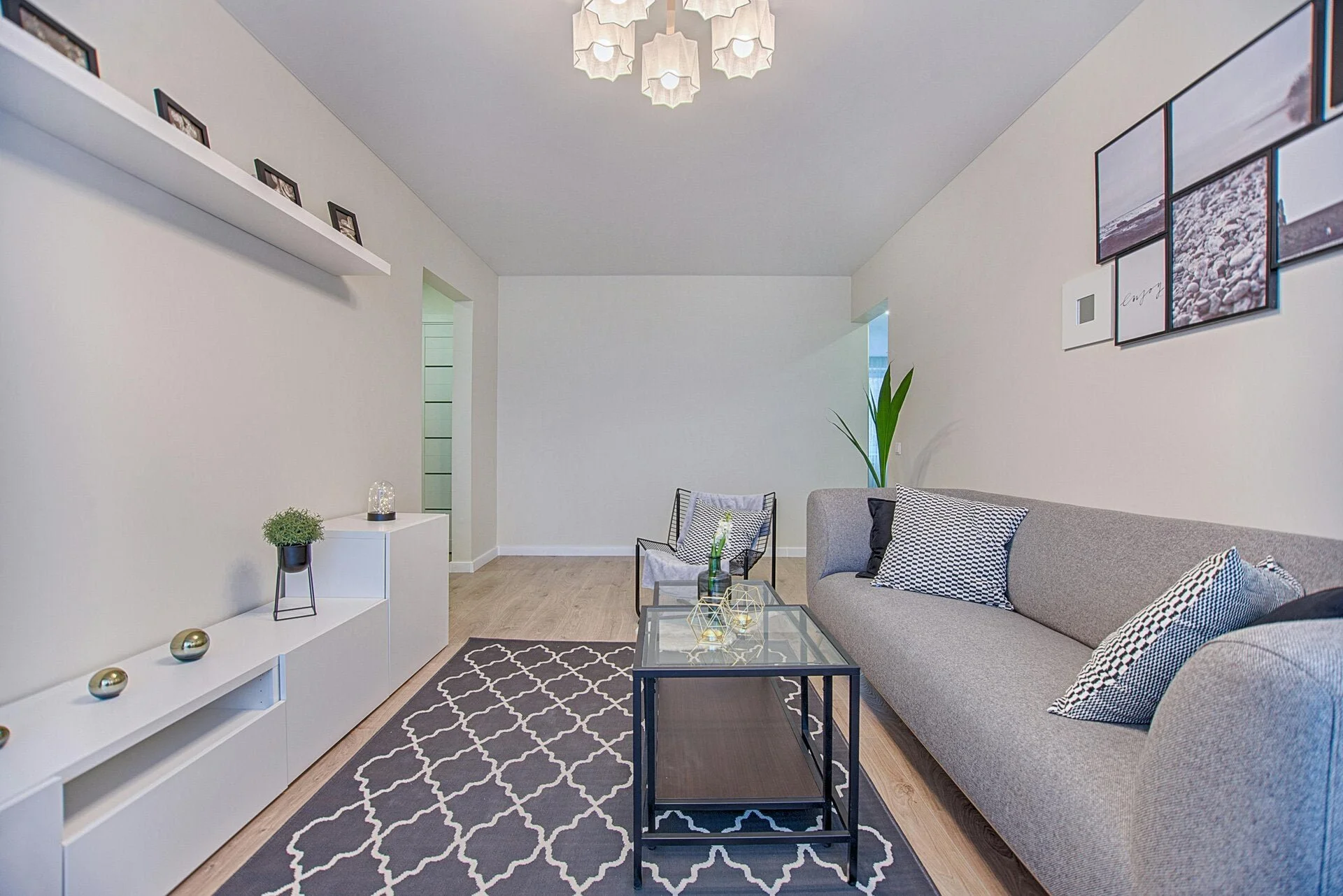 "Freshly decorated modern living room with light neutral walls, grey sofa, feature artwork, and contemporary furnishings."