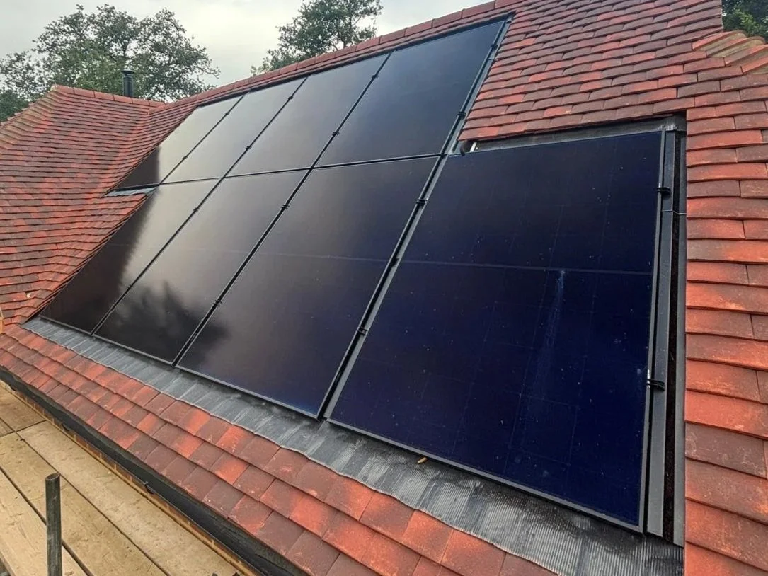 Solar panels installed on a red shingle roof.