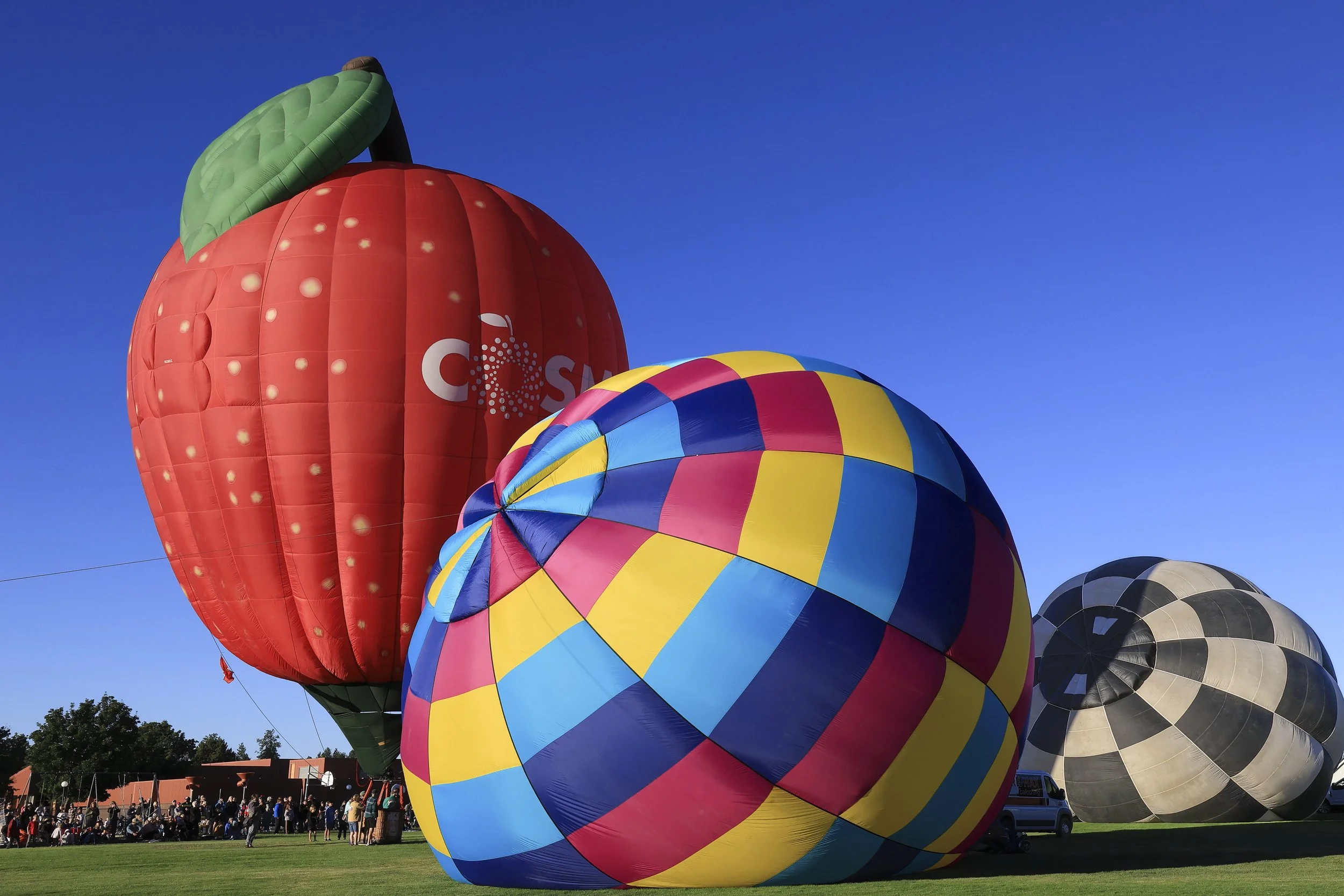 Hot Air Balloons - 

Vibrant hot-air balloons fill the sky with bold bands of yellow, red, turquoise and blue. Sunlight bursts beneath the envelope as the balloon rises above a grassy field, capturing the energy and color of a community celebration.
