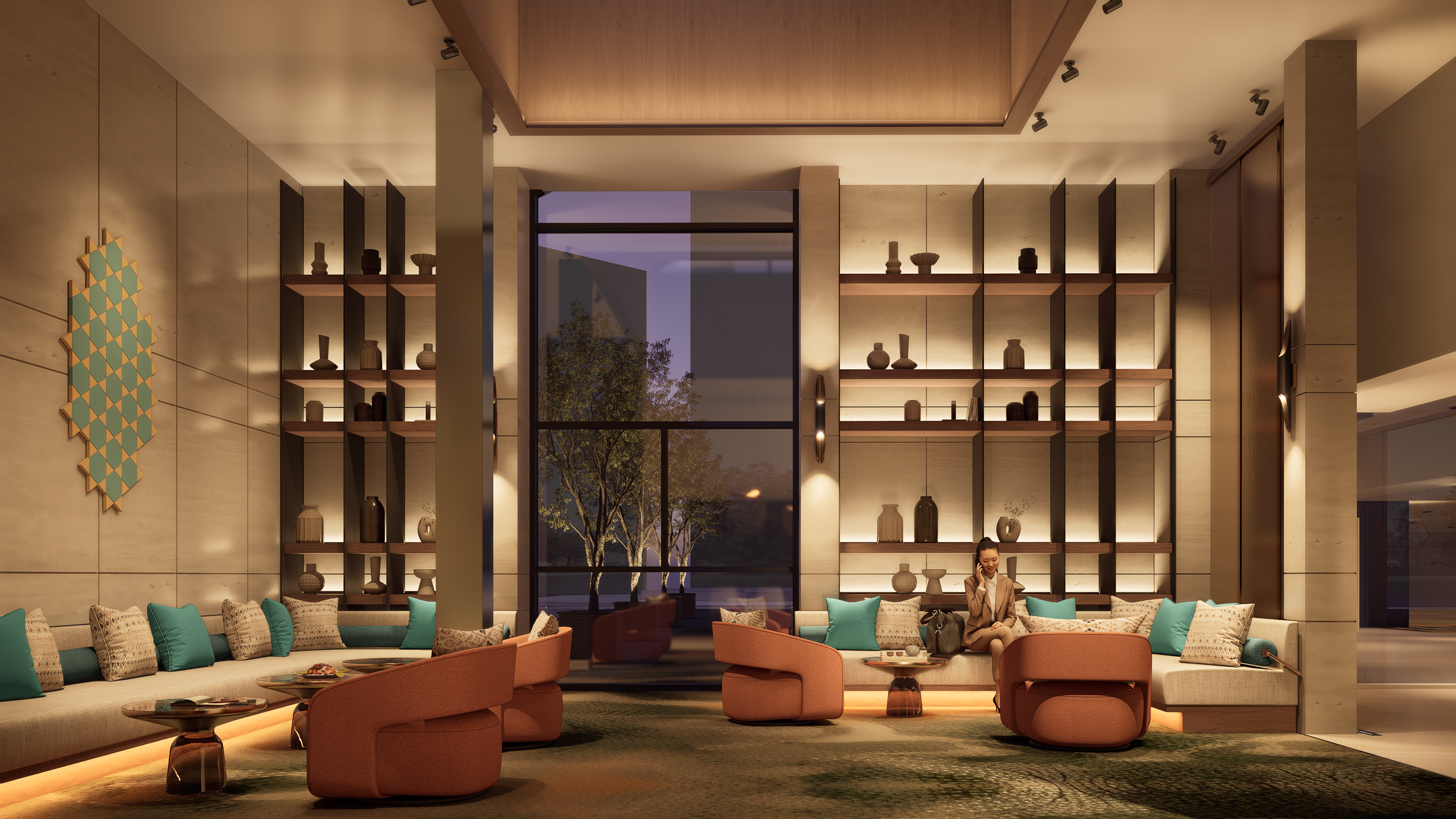 A modern hotel lobby with high ceilings, large windows, and warm lighting. It features a curved sofa with teal and beige pillows, matching accent chairs, and a woman sitting and talking on the phone. Shelves with decorative vases and art pieces are mounted on the walls, and a large window reveals trees outside at dusk.