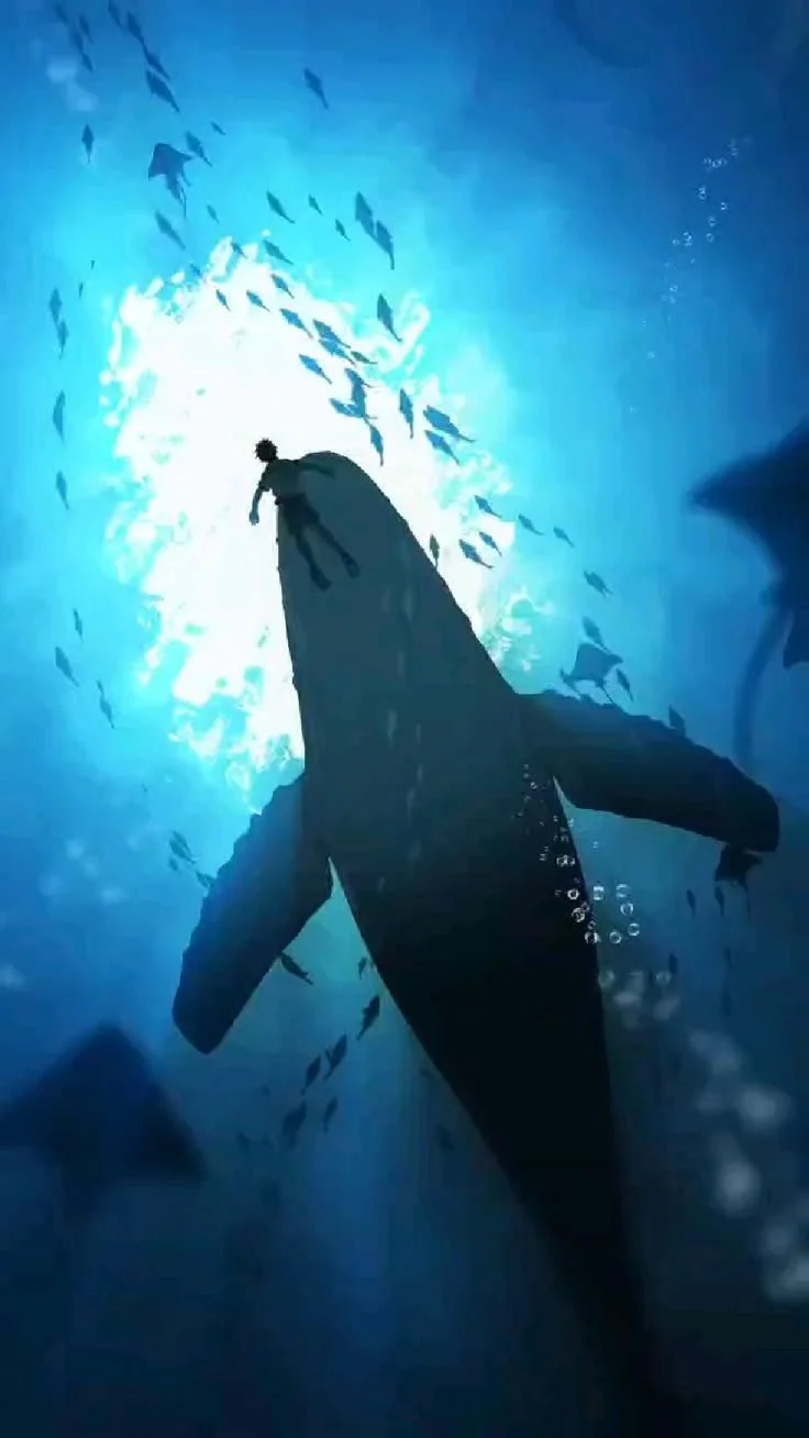 A person is diving into the water from a high rock or cliff, surrounded by a school of fish and illuminated by sunlight shining through the water.