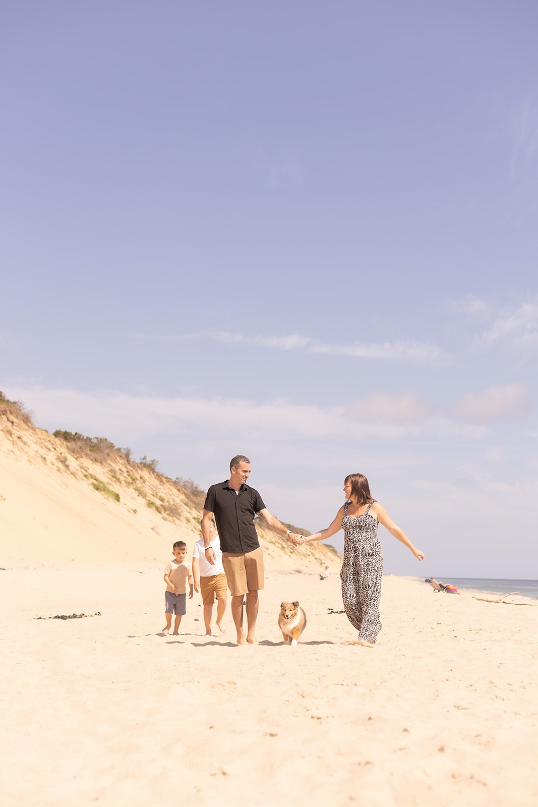 Playful family beach session in Wellfleet with kids running through the water, natural and unposed moments