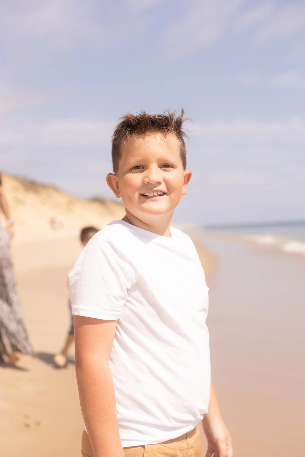 Playful family beach session in Wellfleet with kids running through the water, natural and unposed moments