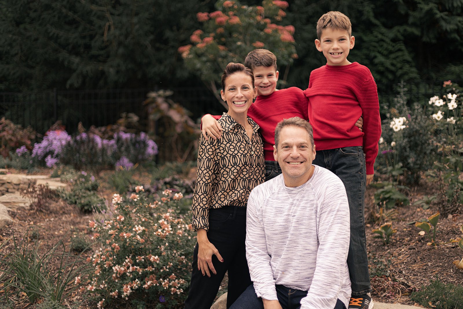 Family of four walking together outdoors during a relaxed fall session in Doylestown, candid and natural family photography