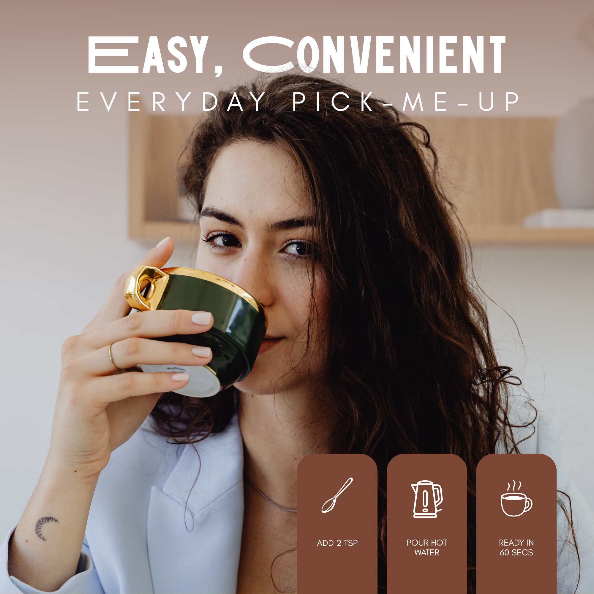 A woman with wavy brown hair and a tattoo on her wrist holds a dark green mug with a gold rim, smiling and looking at the camera, in a well-lit room with a white wall and wooden shelf background.