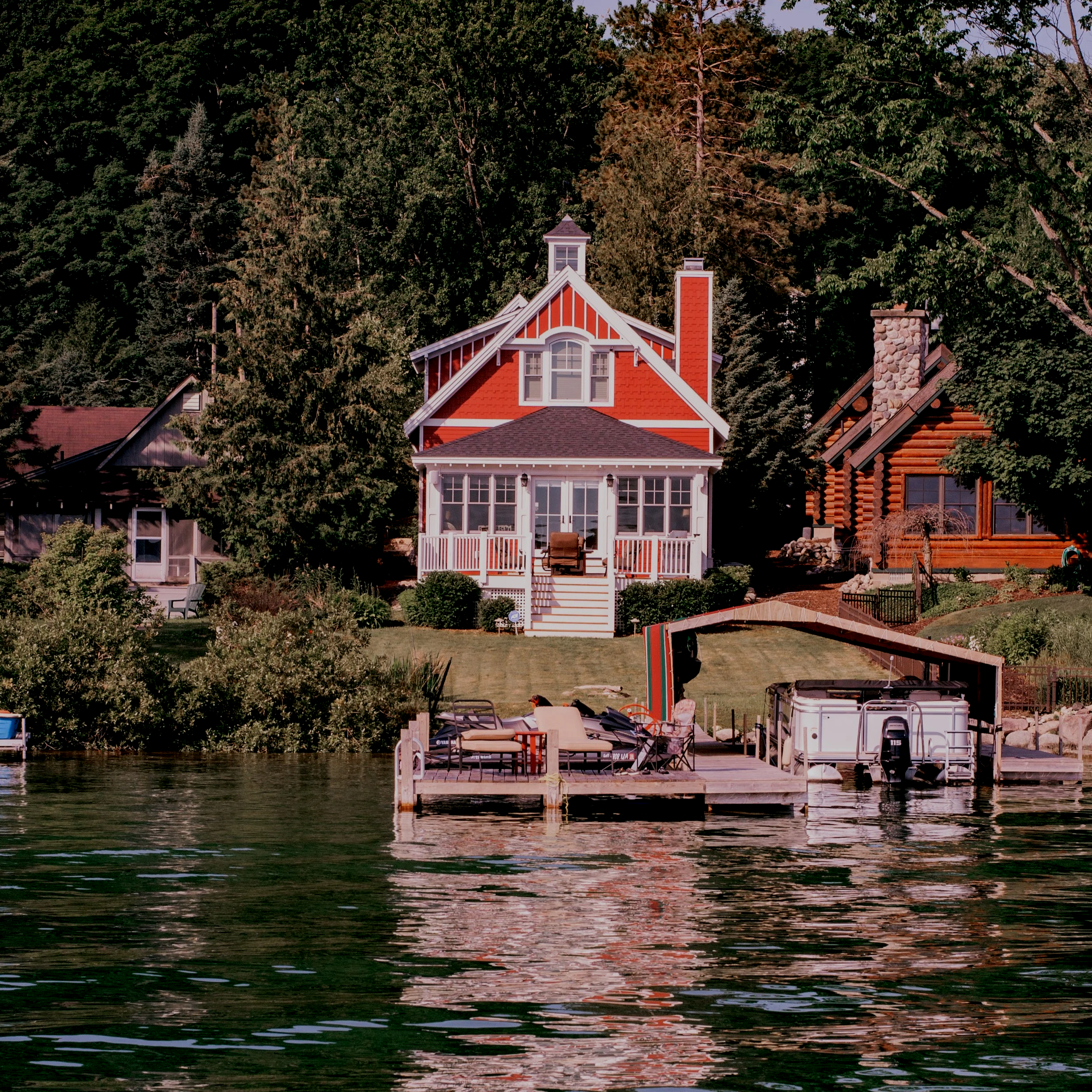 A house on the lakeside with boats, furniture, and clothing on a dock.