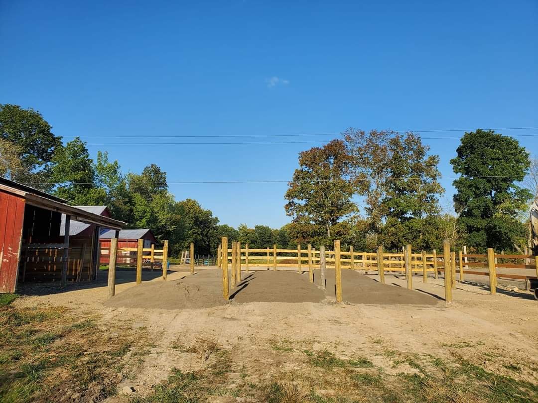 A horse pen with truck loads of sand 