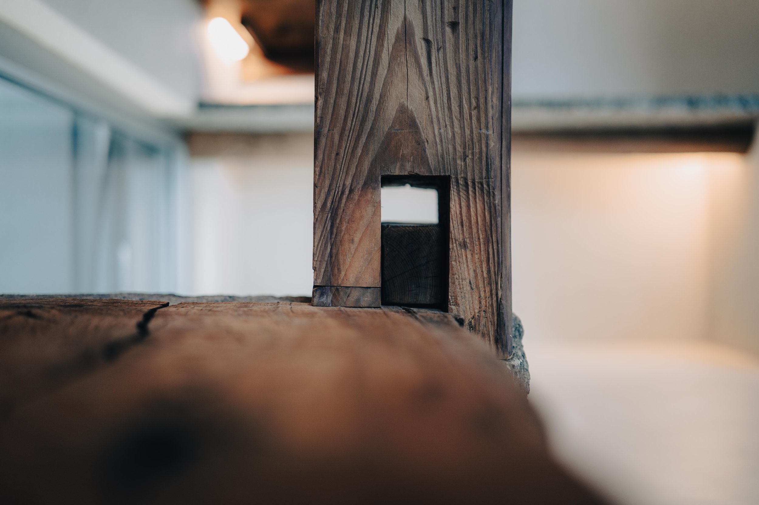 NUUT Aewol 눗애월 Close-up of a wooden furniture leg showing a detailed, square joint.
