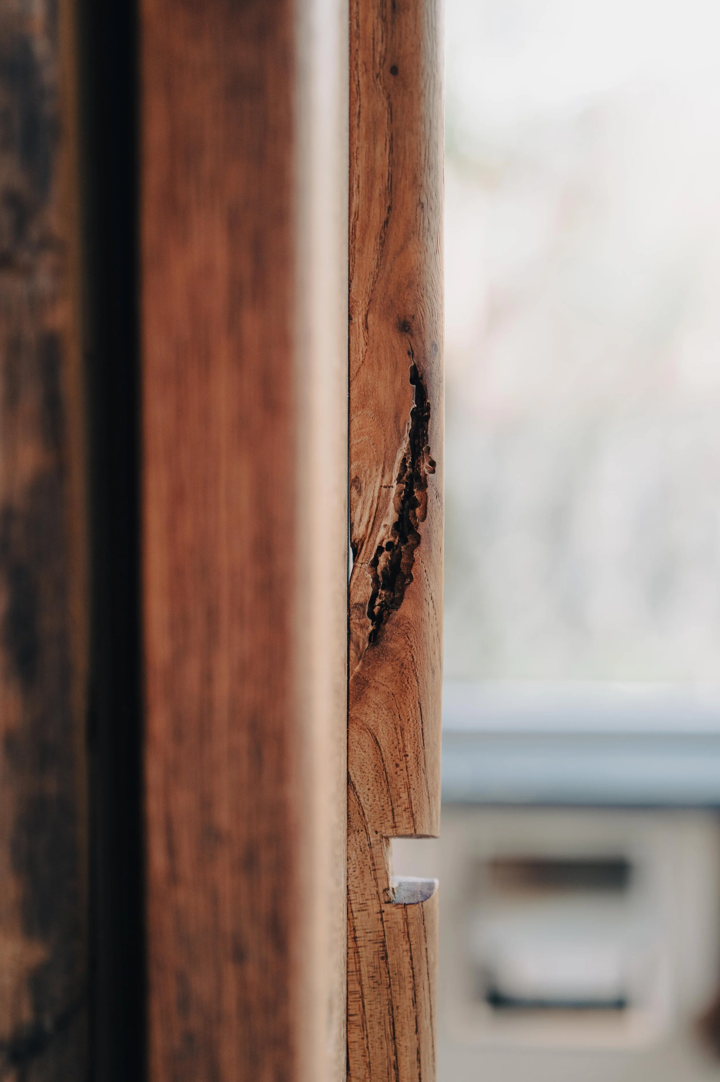 NUUT Aewol 눗애월Close-up of a wooden cabinet with a visible crack or damage on the side panel.