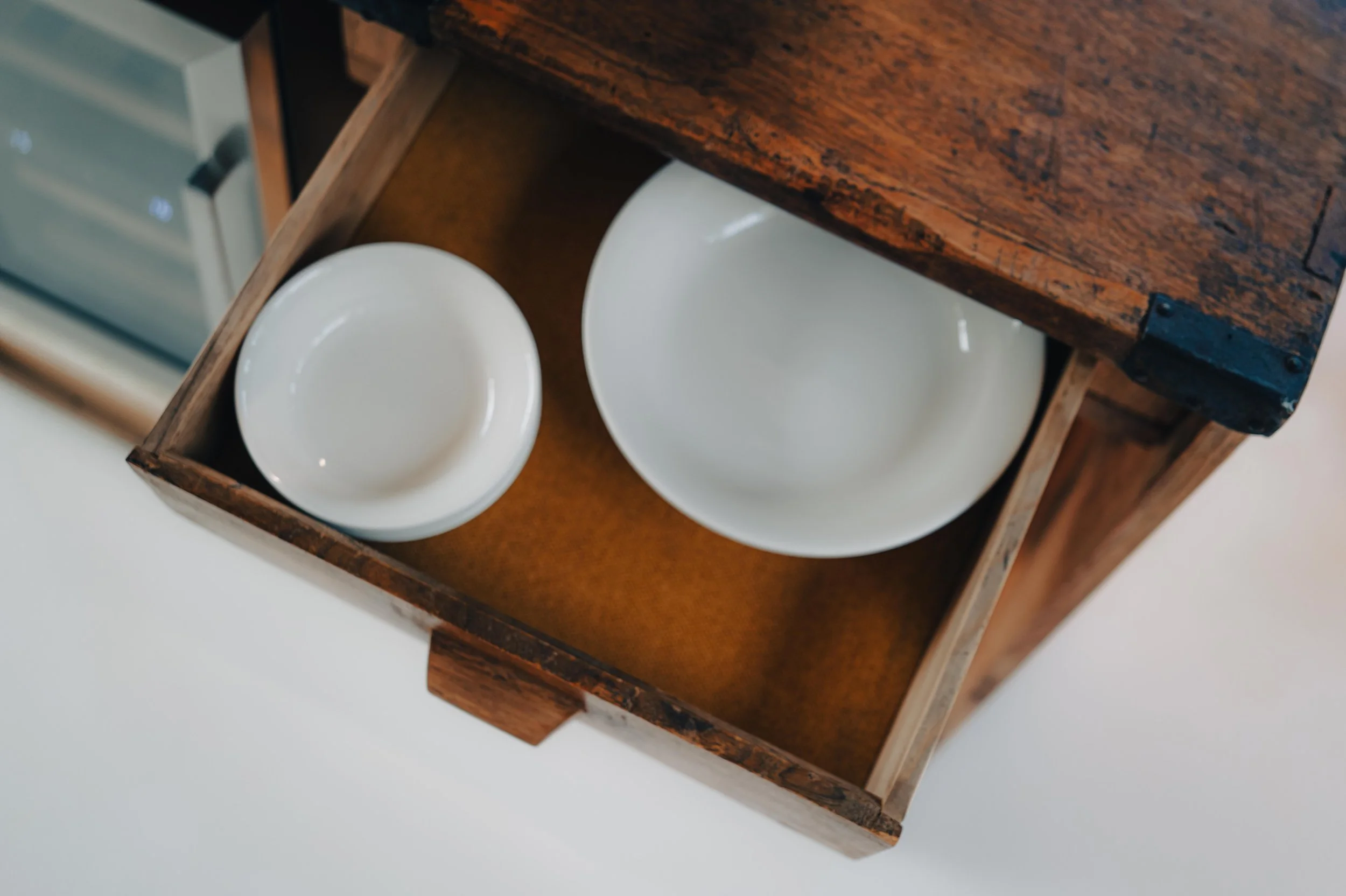 NUUT Aewol 눗애월 Open wooden drawer with two white ceramic bowls, one small and one large, inside a kitchen.