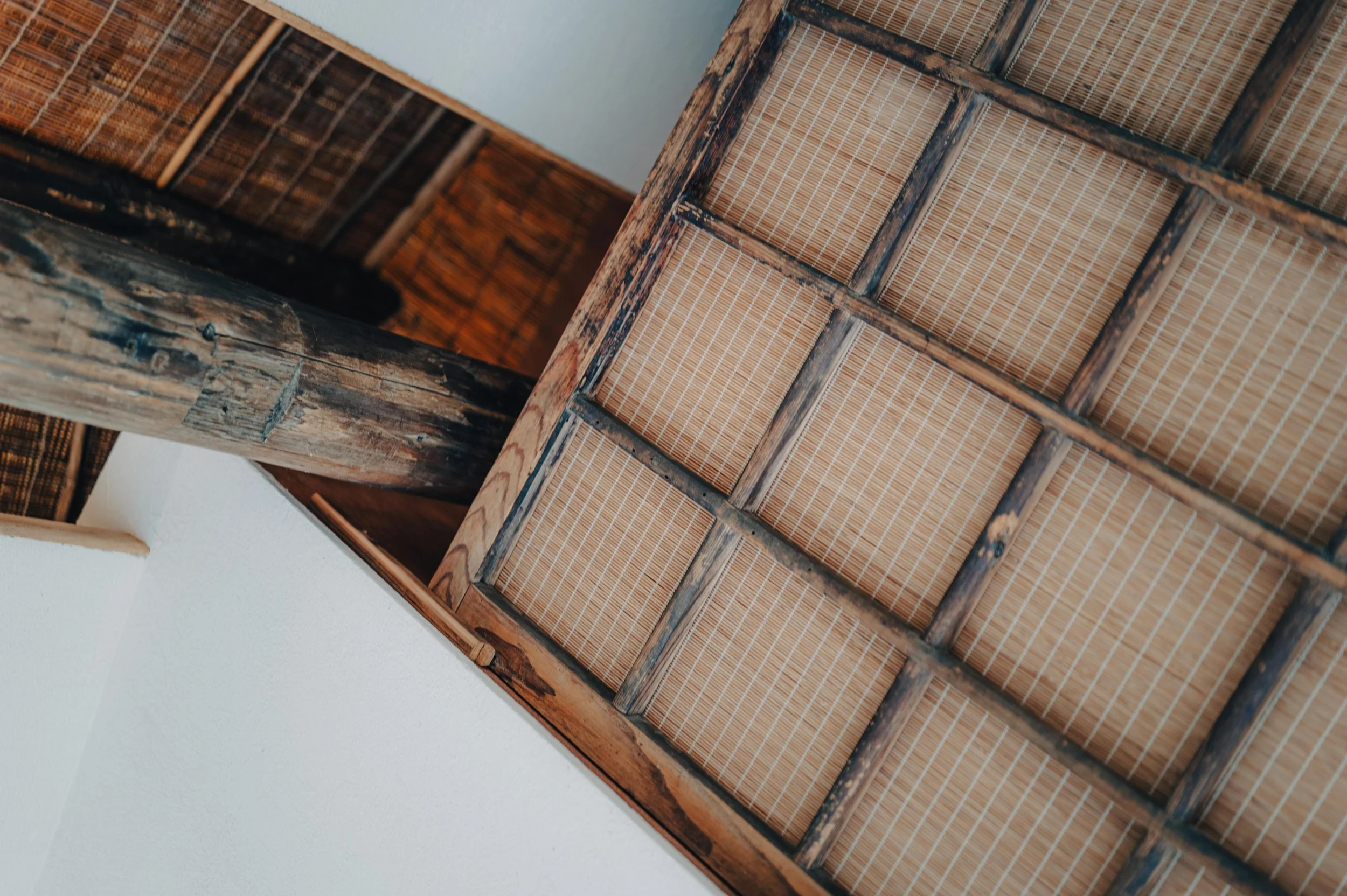 NUUT Aewol 눗애월 Close-up of a wooden ceiling with bamboo panels.