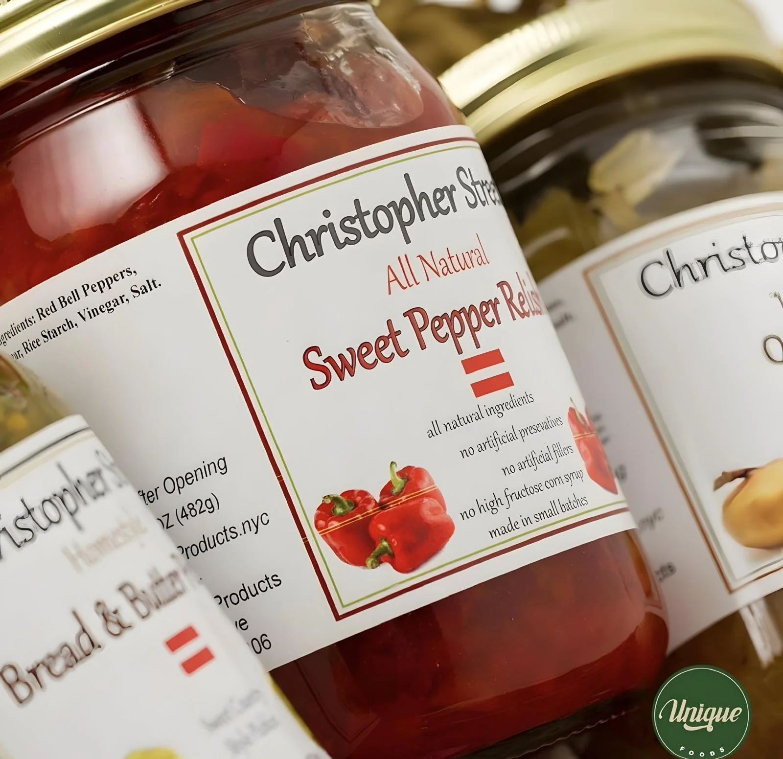Close-up of a jar of Christopher Street Sweet Pepper Relish with labels showing ingredients and features, including red bell peppers, and additional jars in the background.