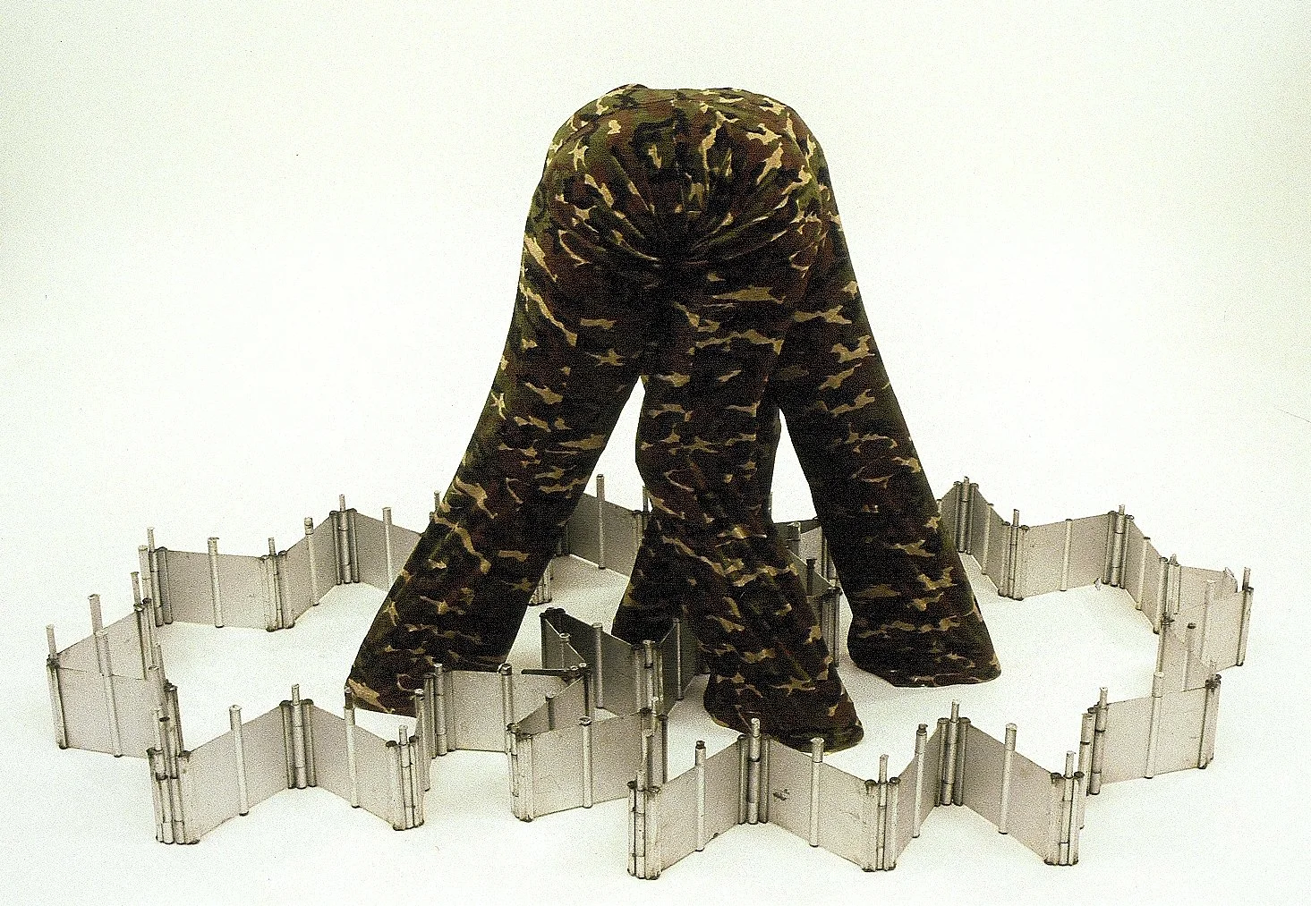 Tug of War. Camouflage pants, armature, found metal.